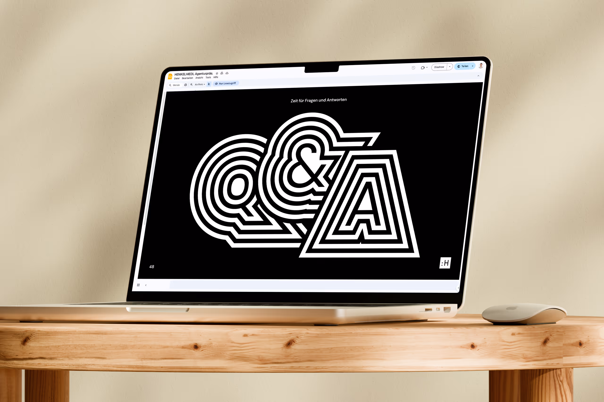 Open laptop on wooden table displaying a black screen with white stylized 'Q & A' text for questions and answers.