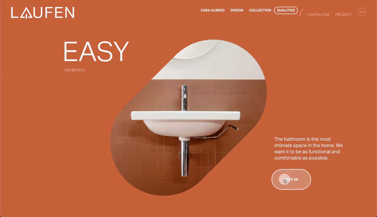 Modern white wall-mounted bathroom sink with chrome faucet against brown tiled wall.