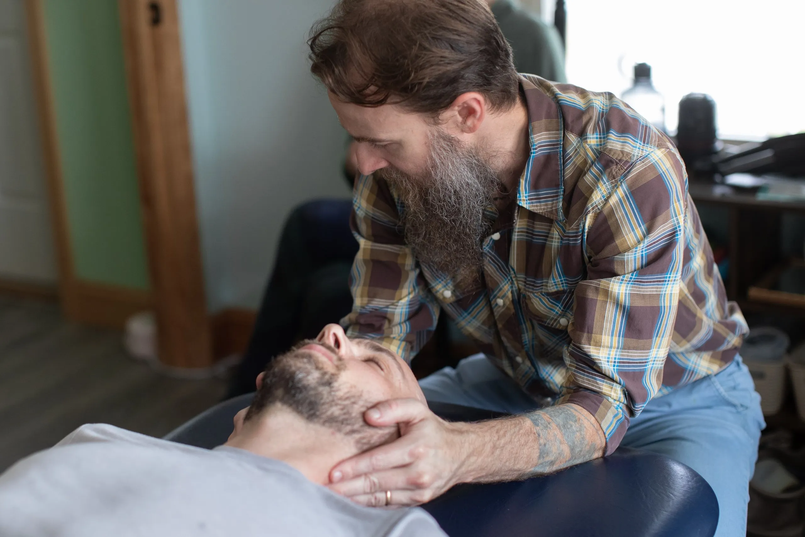 Dr. Joseph McCue performing a cervical spine adjustment on a patient lying on a treatment table
