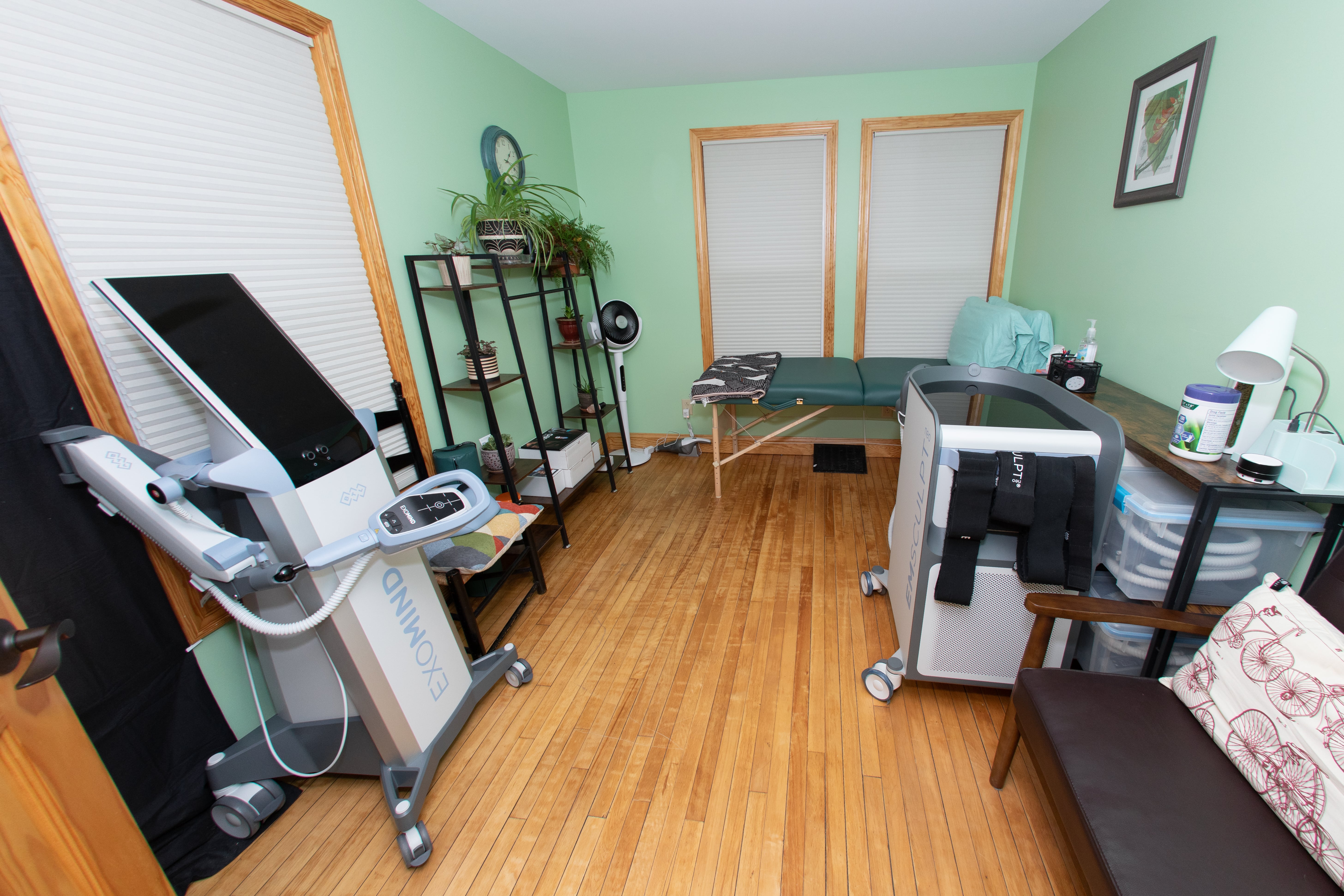 Treatment room equipped with Exomind and Emsculpt Neo devices alongside an examination table
