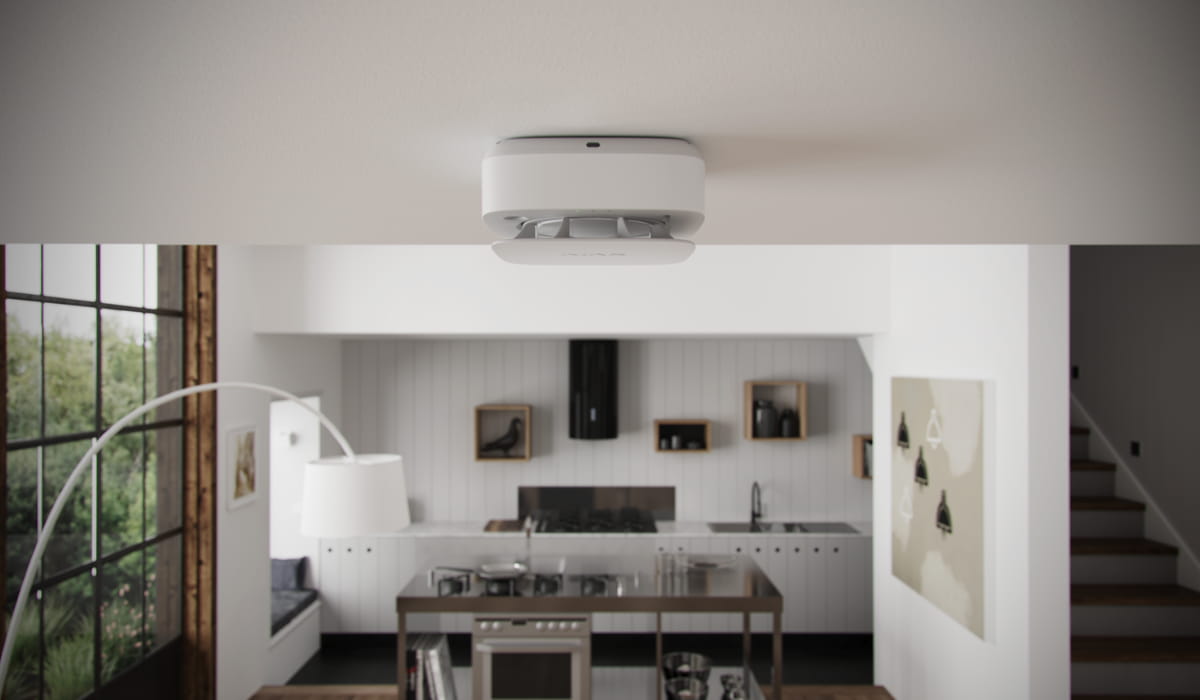 Ajax FireProtect 2 smoke detector installed on the ceiling of a modern home kitchen.
