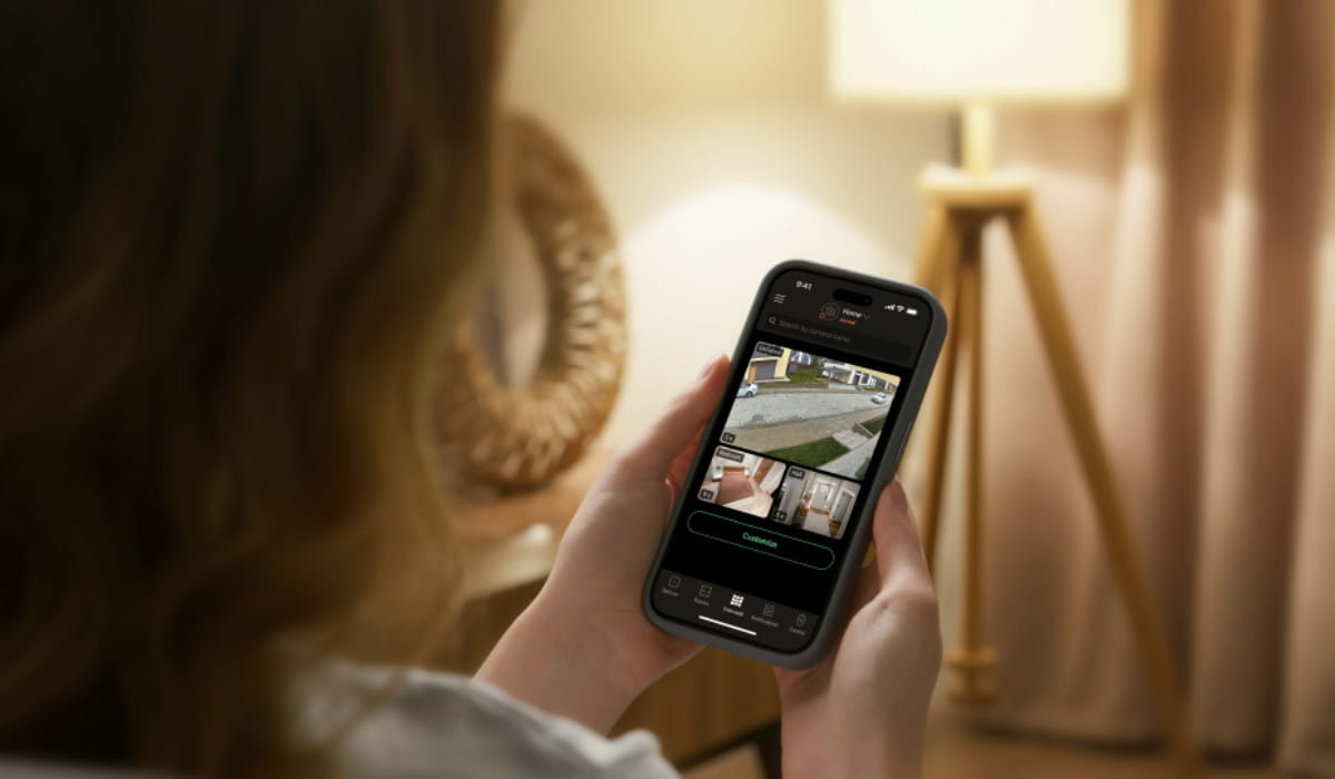 Homeowner viewing Ajax security camera feeds and system controls in the mobile app.