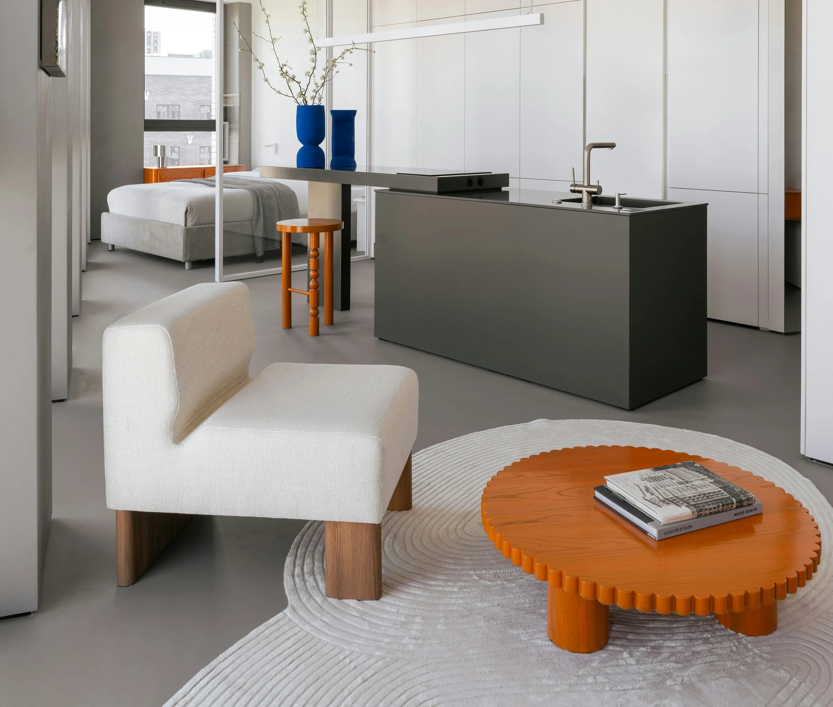 A small apartment featurign a bed a chair and a table