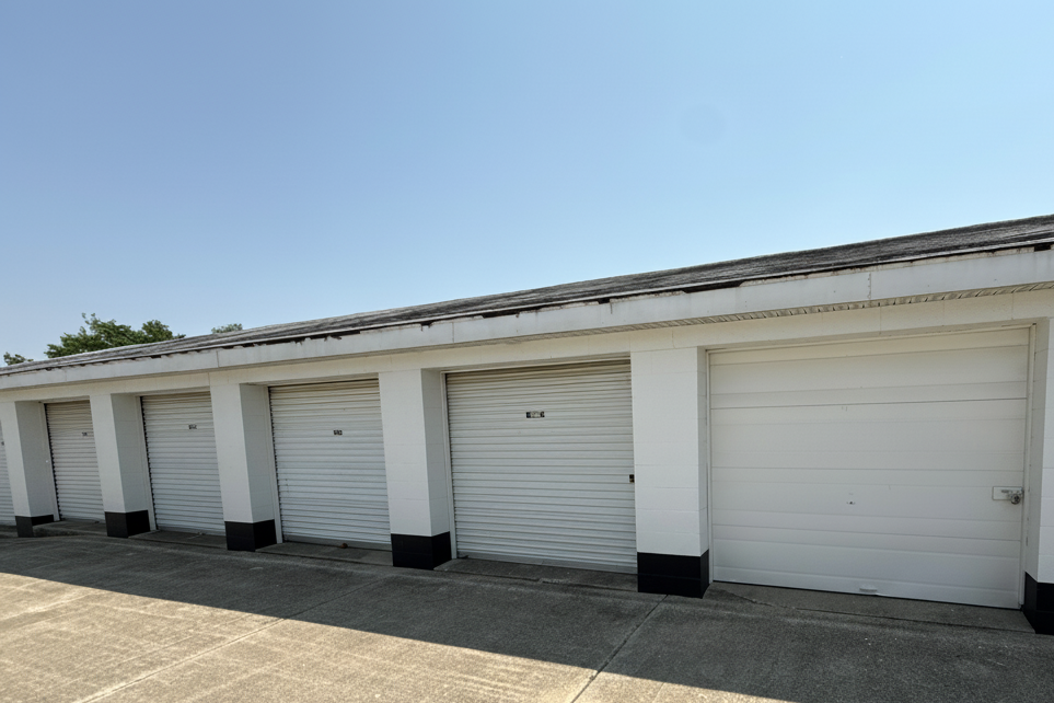 Exterior view of drive up storage buildings with white doors and paved access lanes in Kokomo IN
