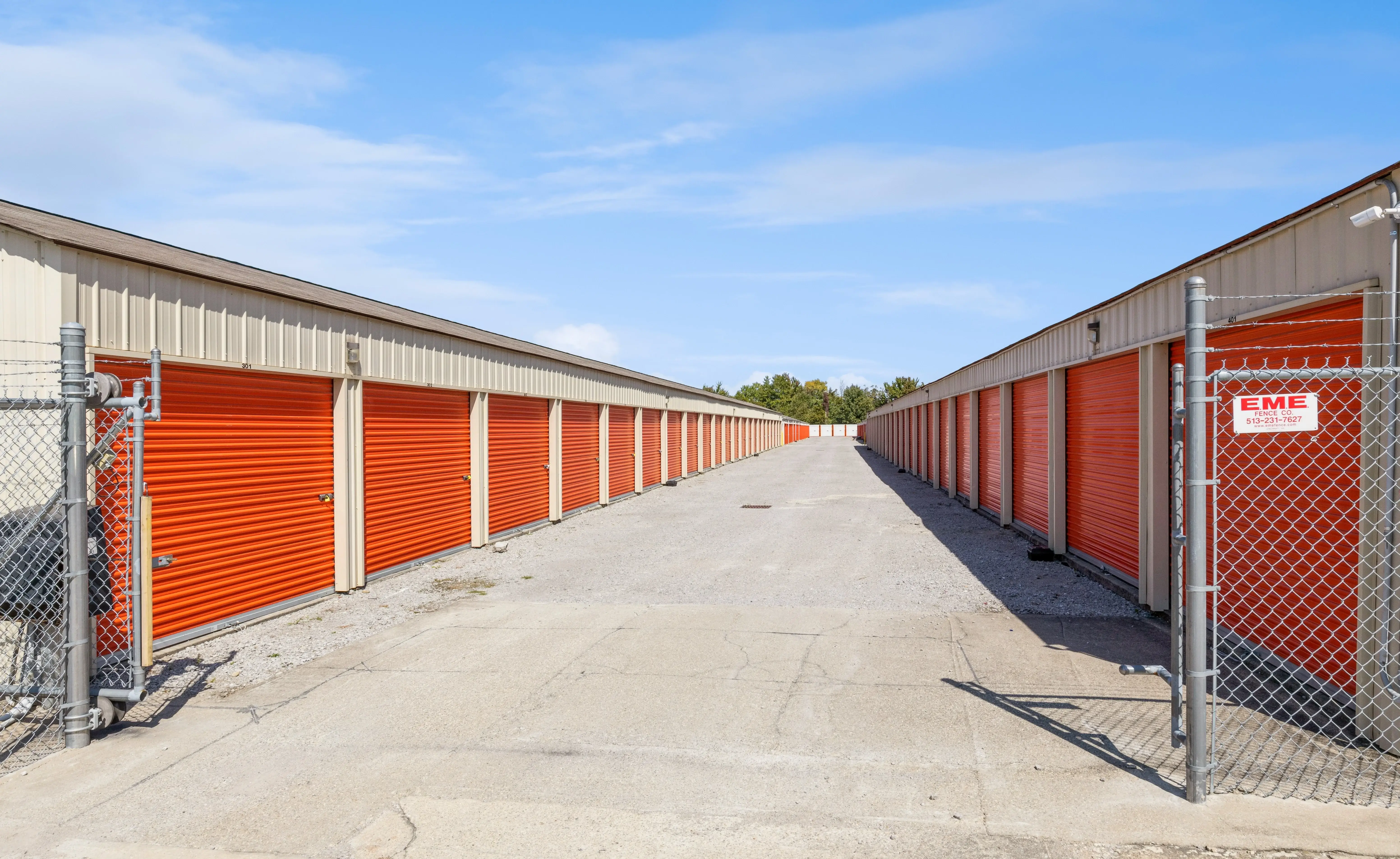 Drive up storage buildings with orange roll up doors along gravel access lanes in Batavia OH