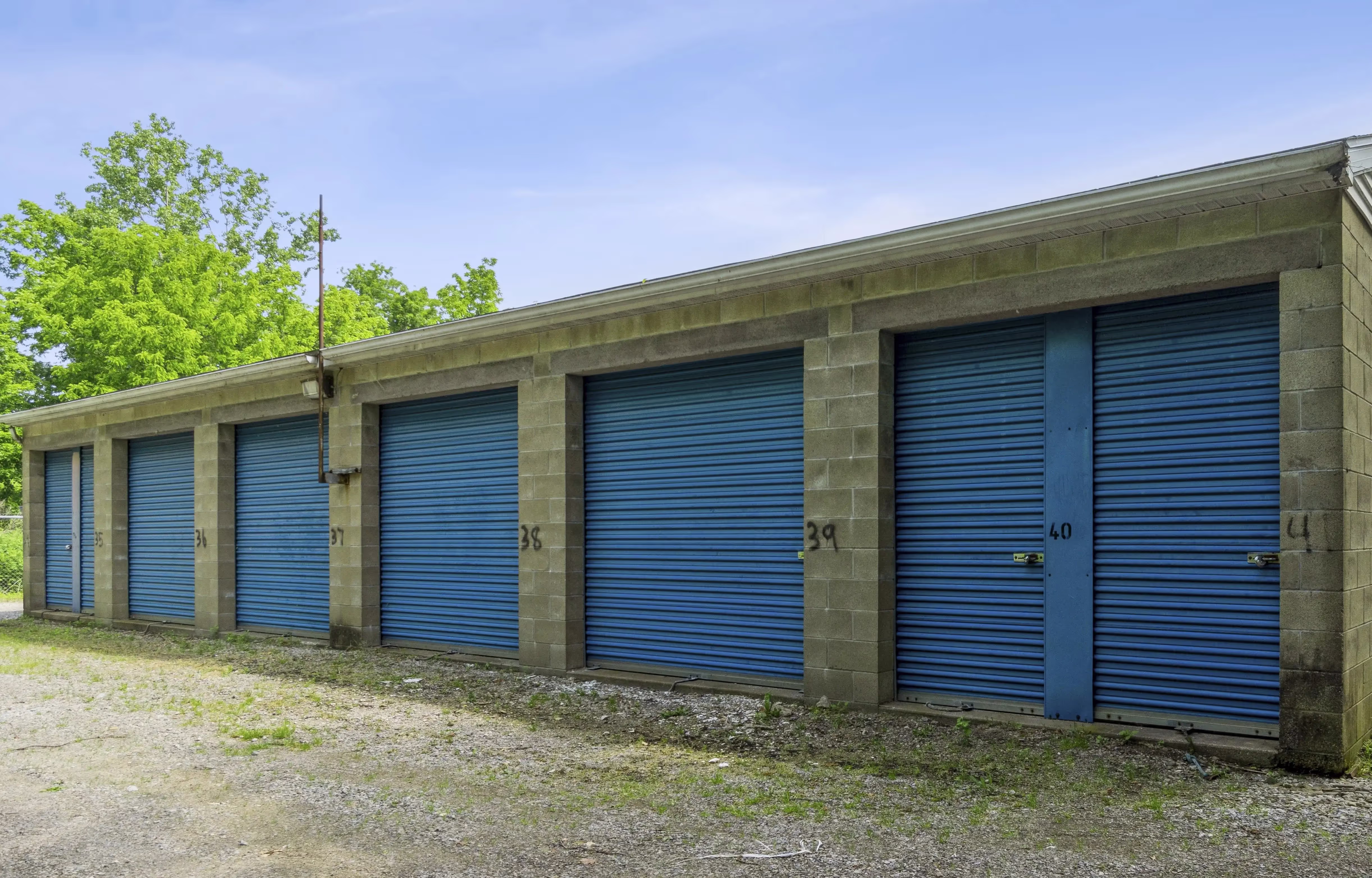 Exterior row of blue door storage units with gravel access lane at our Fairview PA facility