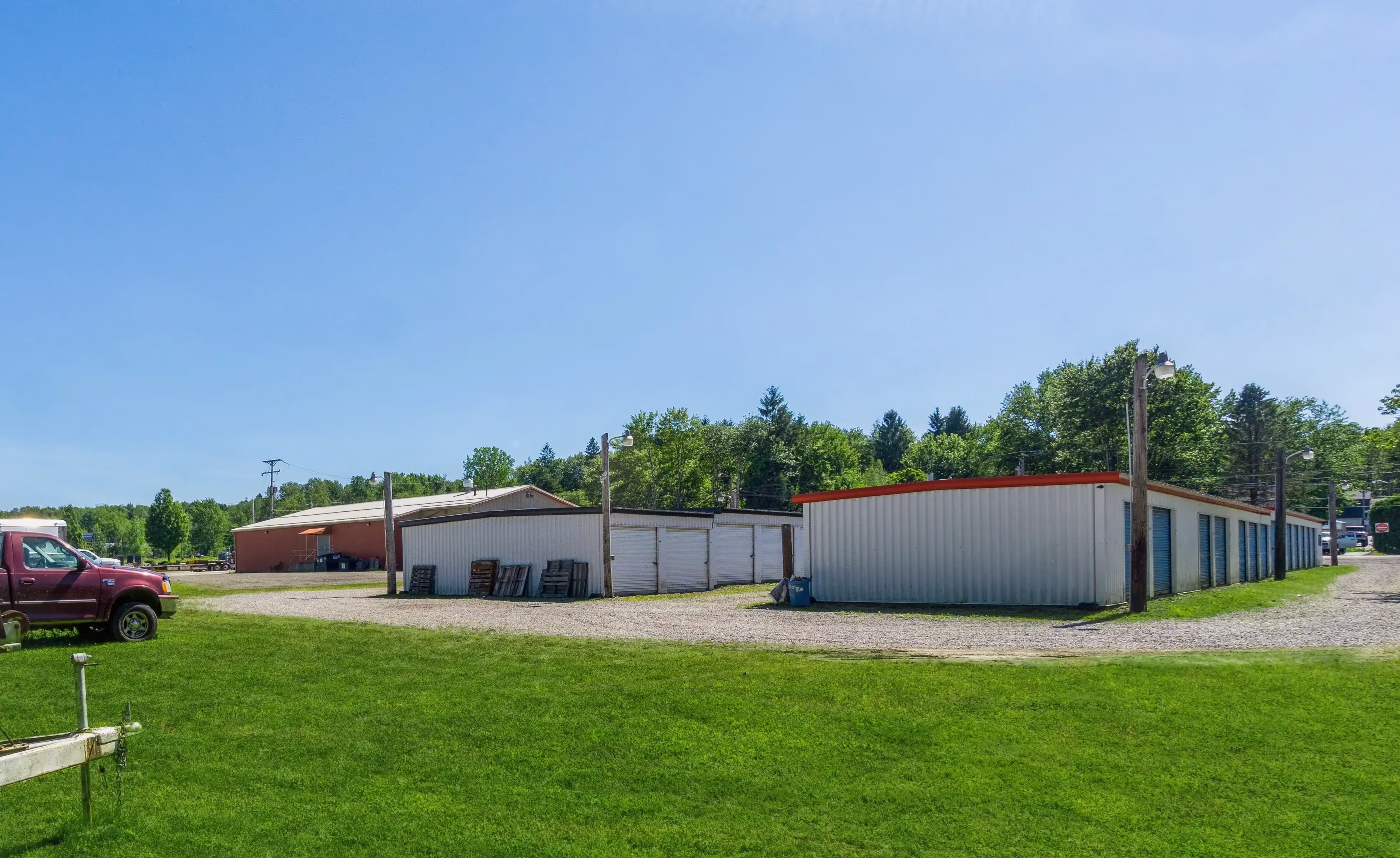 Wide view of gray and blue storage buildings on a grassy lot with gravel access lanes at our Erie PA facility