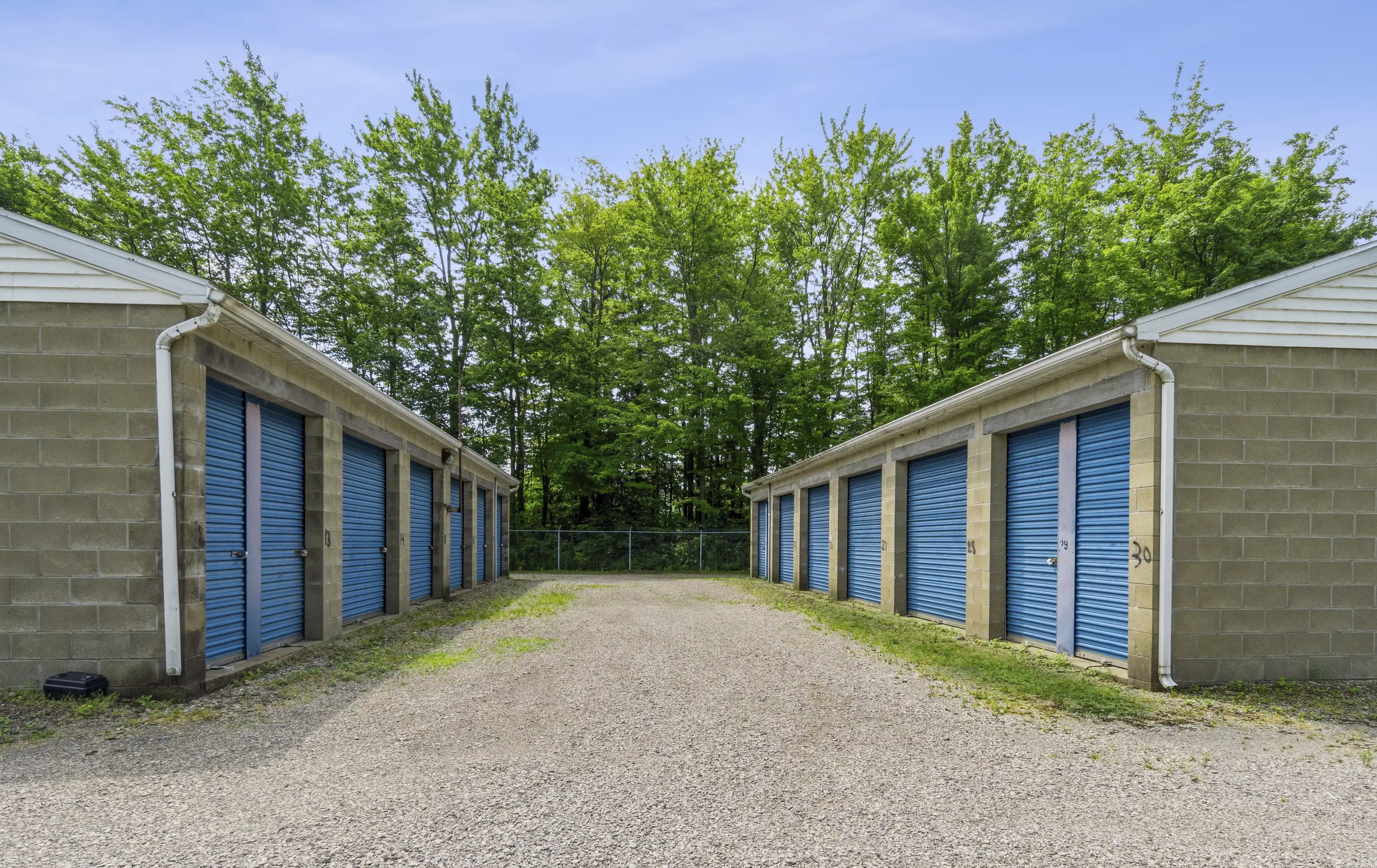 Drive up storage buildings with blue doors and gravel access lanes at our Fairview PA location