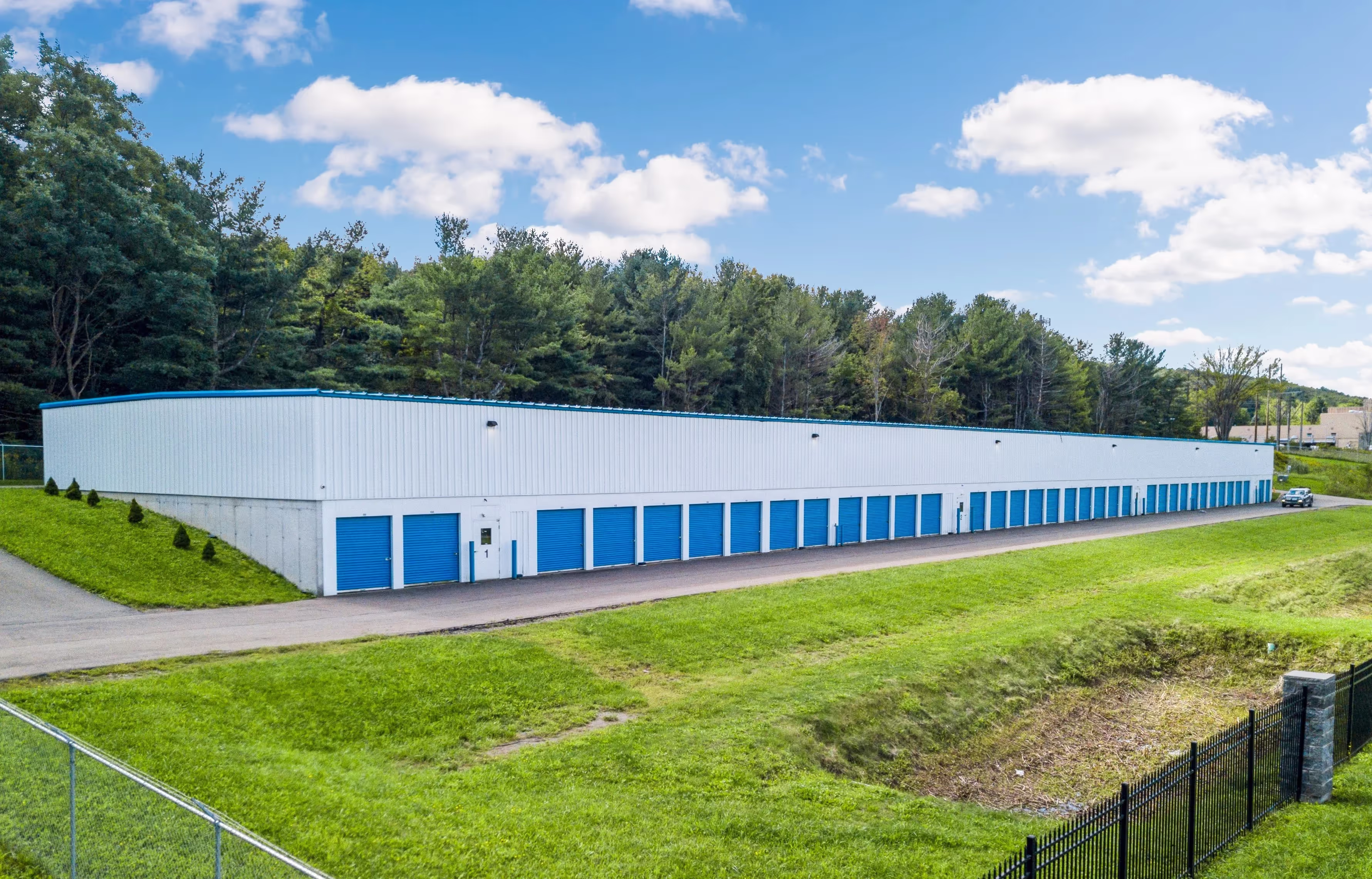 Drive up storage buildings with blue doors on hillside at our Ithaca NY storage facility