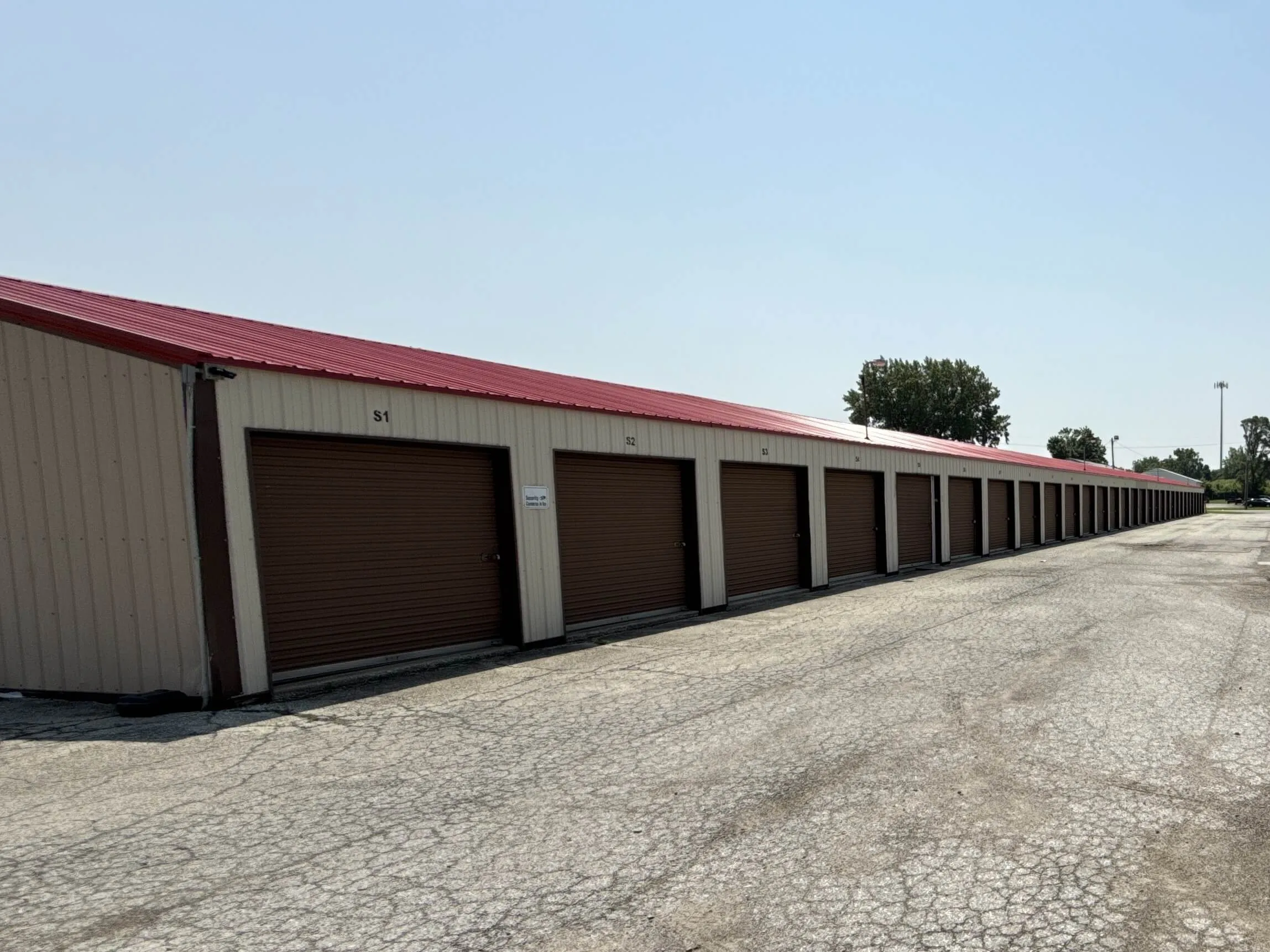 Drive up storage buildings with brown doors and gravel access lanes at our Kokomo IN storage location