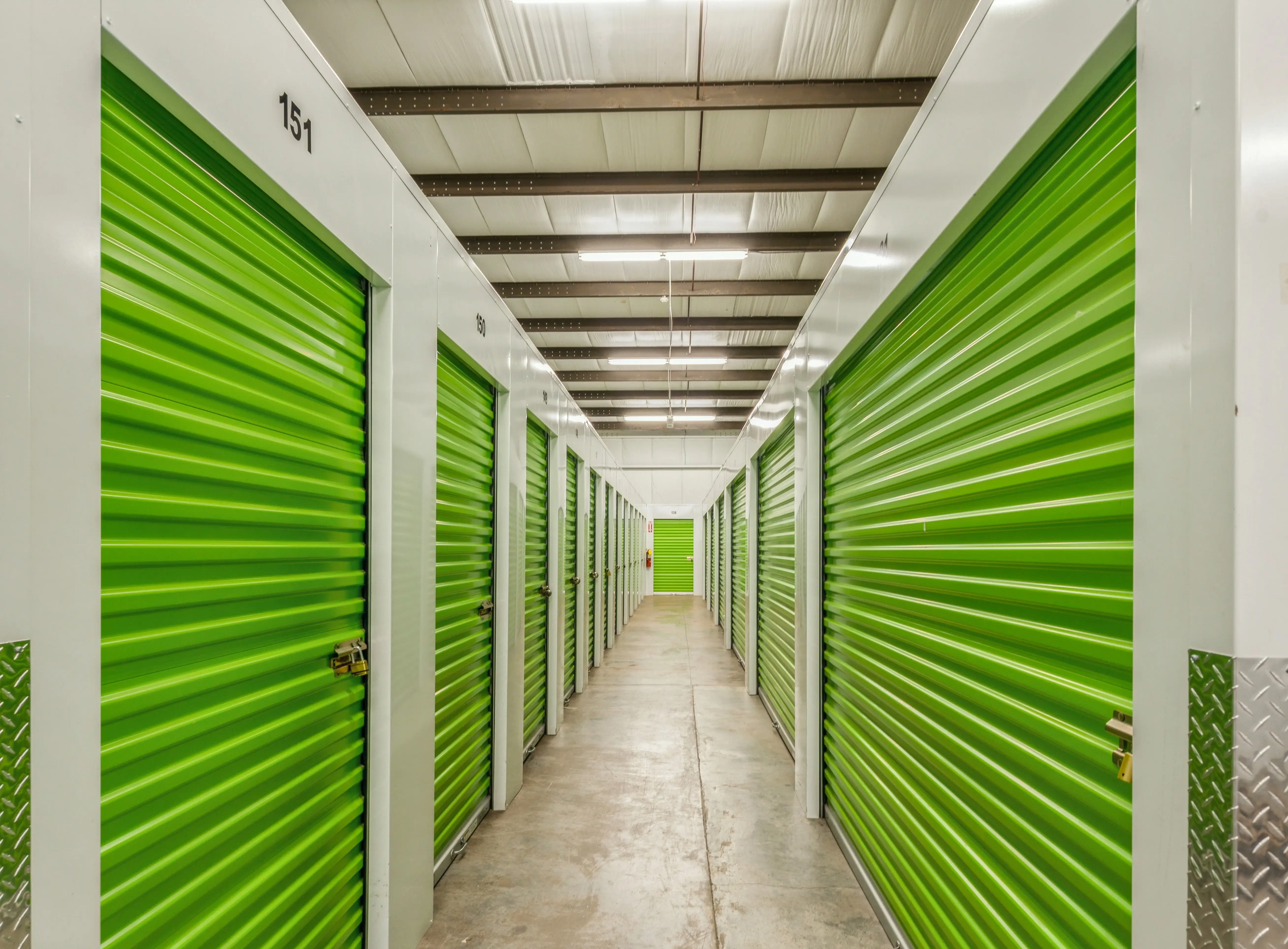 Interior hallway of climate controlled storage units with green roll up doors in Milledgeville GA