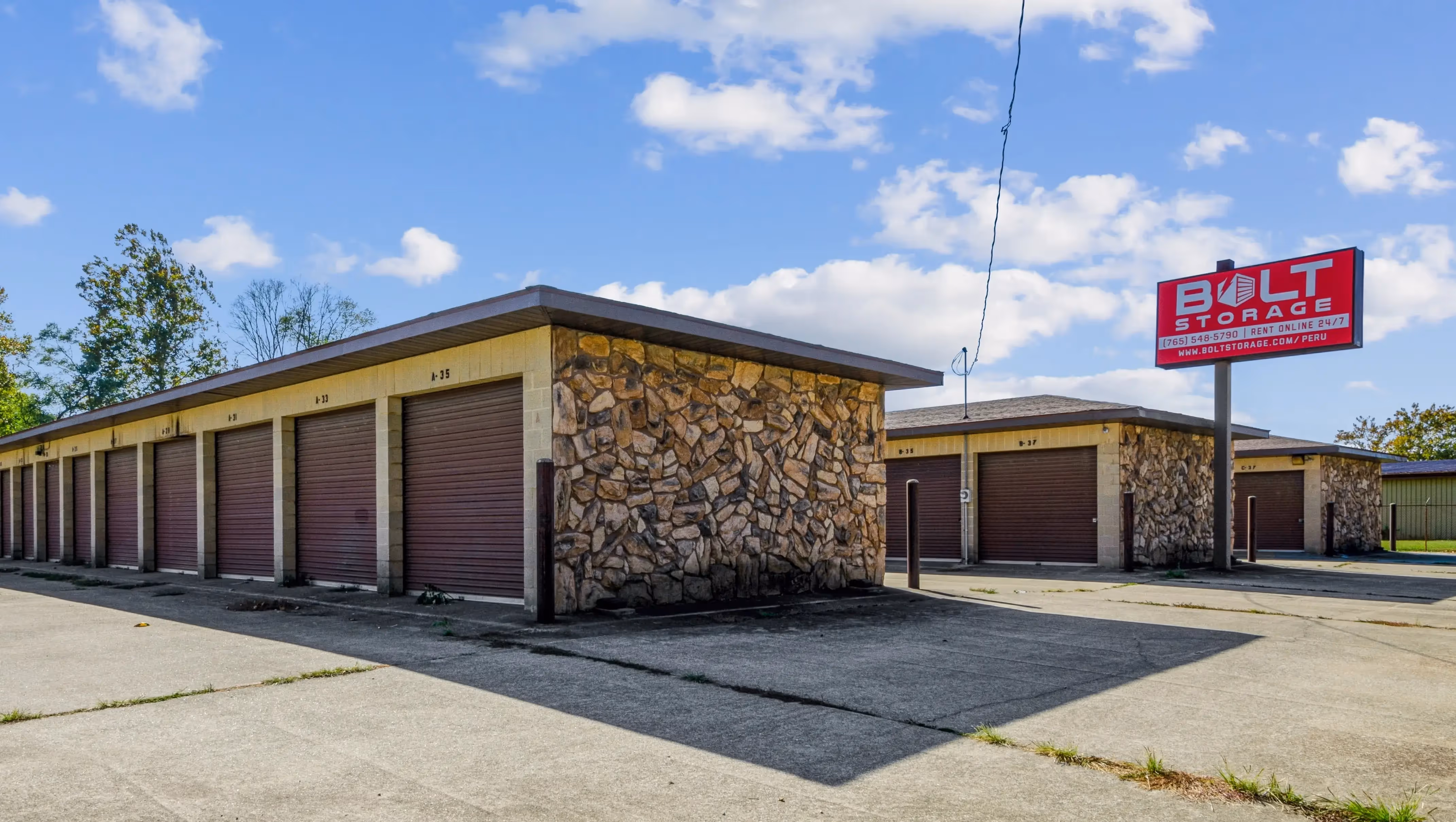 Two self storage buildings in peru, IN and a red Bolt Storage sign