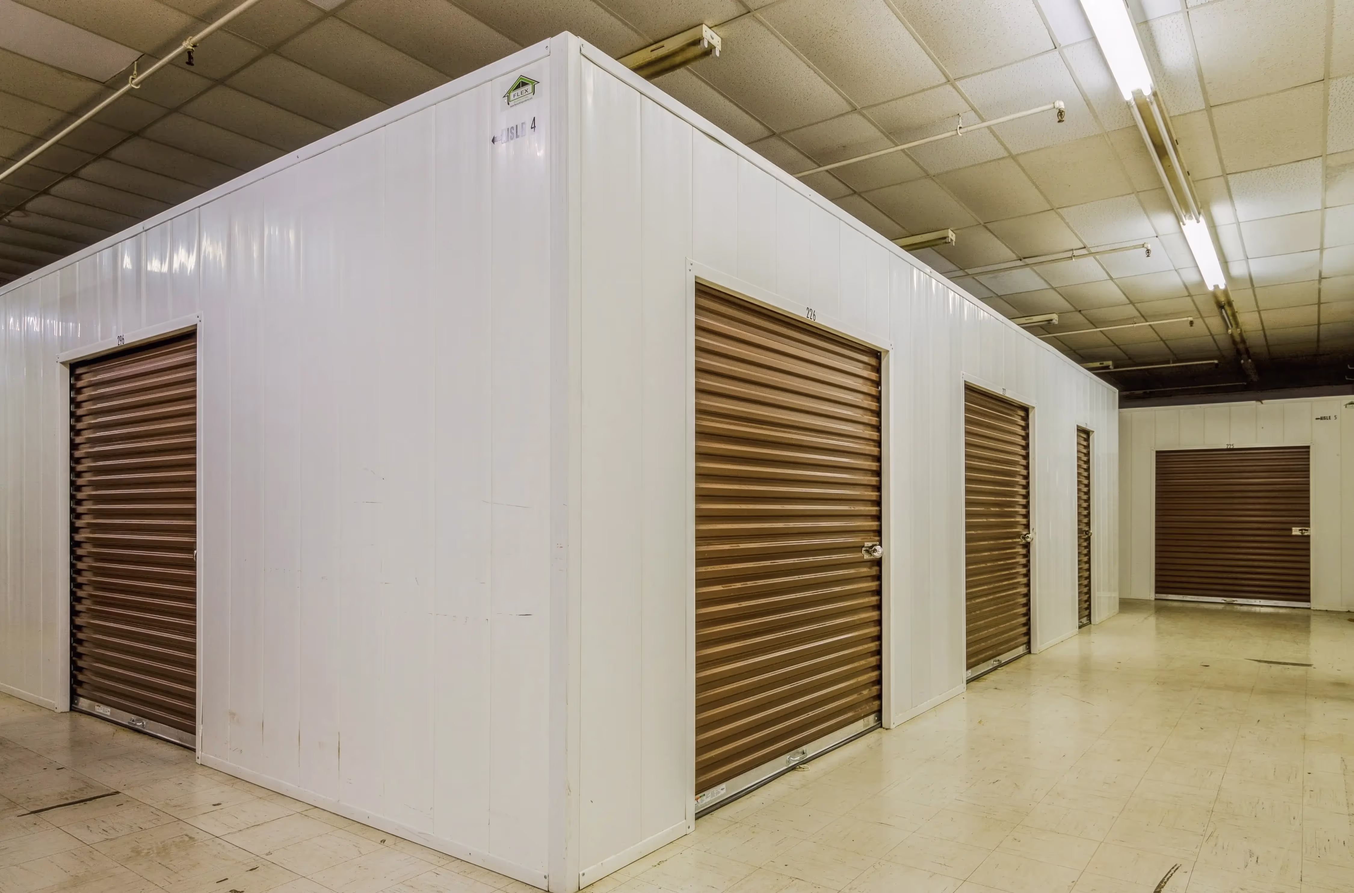 Interior storage area showing corner units with brown roll up doors and smooth concrete flooring in Peru IN