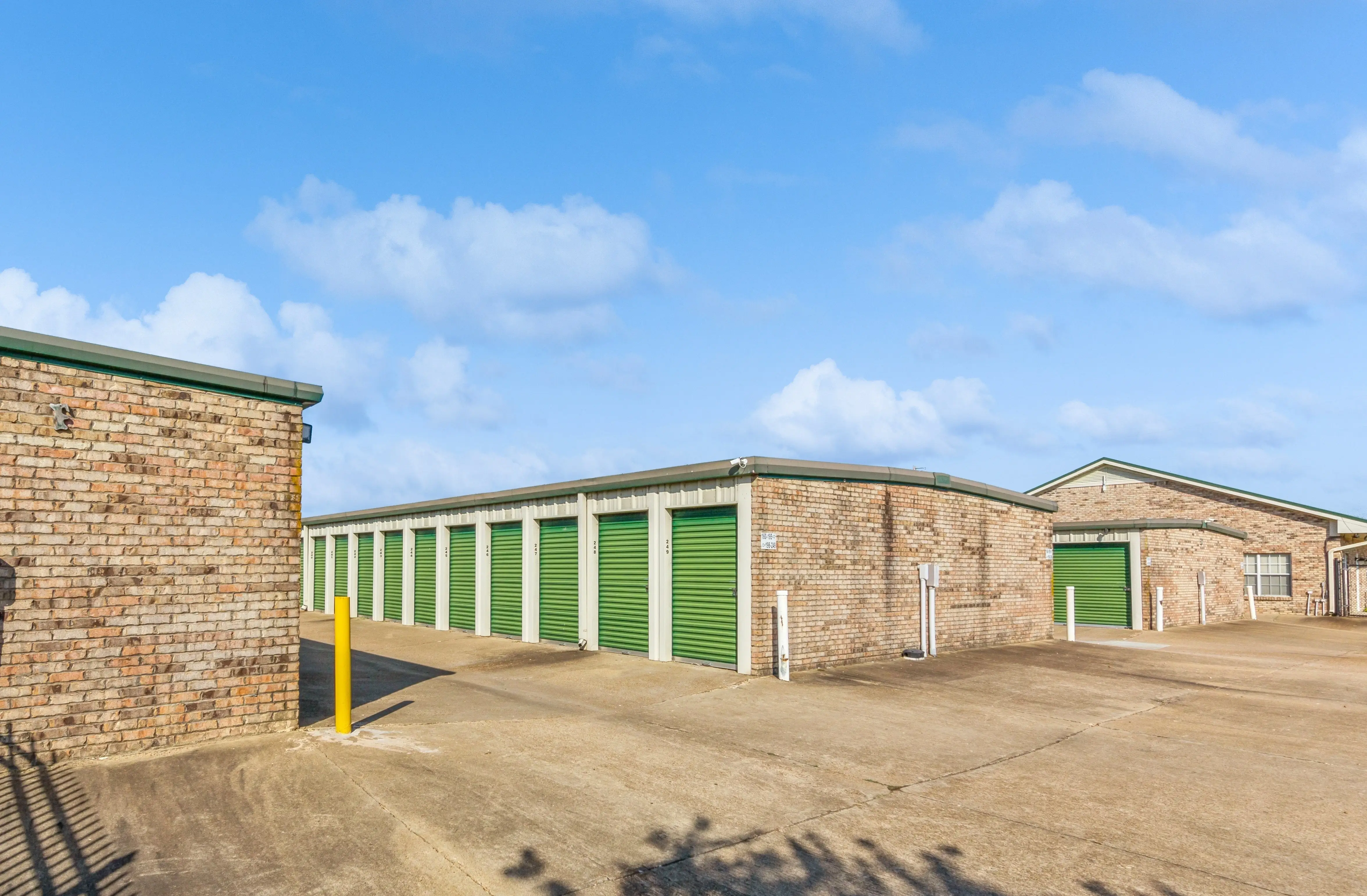 Brick storage buildings with green roll up doors and paved driveway at our Robinsonville MS facility