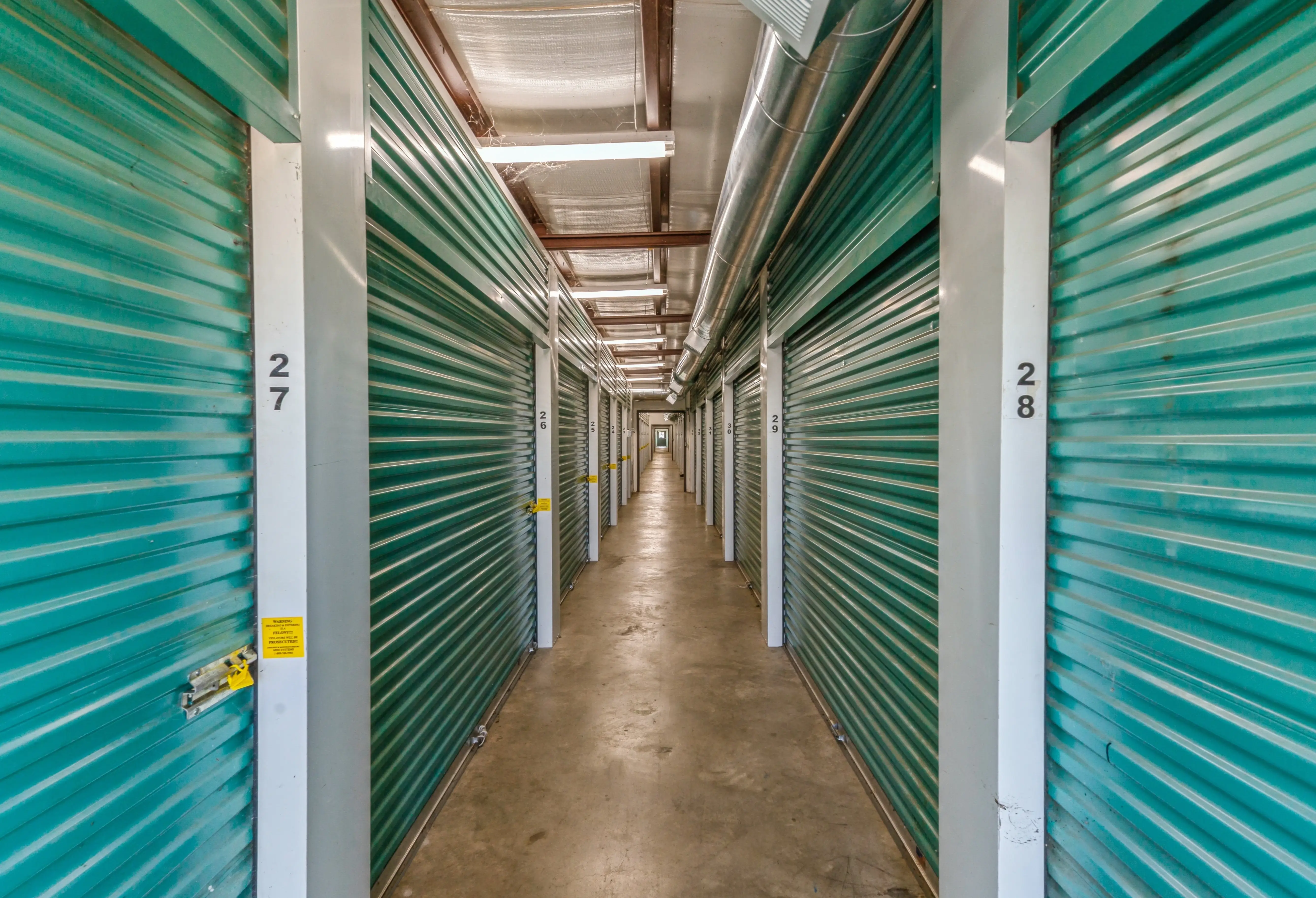 Interior storage units with green doors beside brick buildings at our Robinsonville MS location