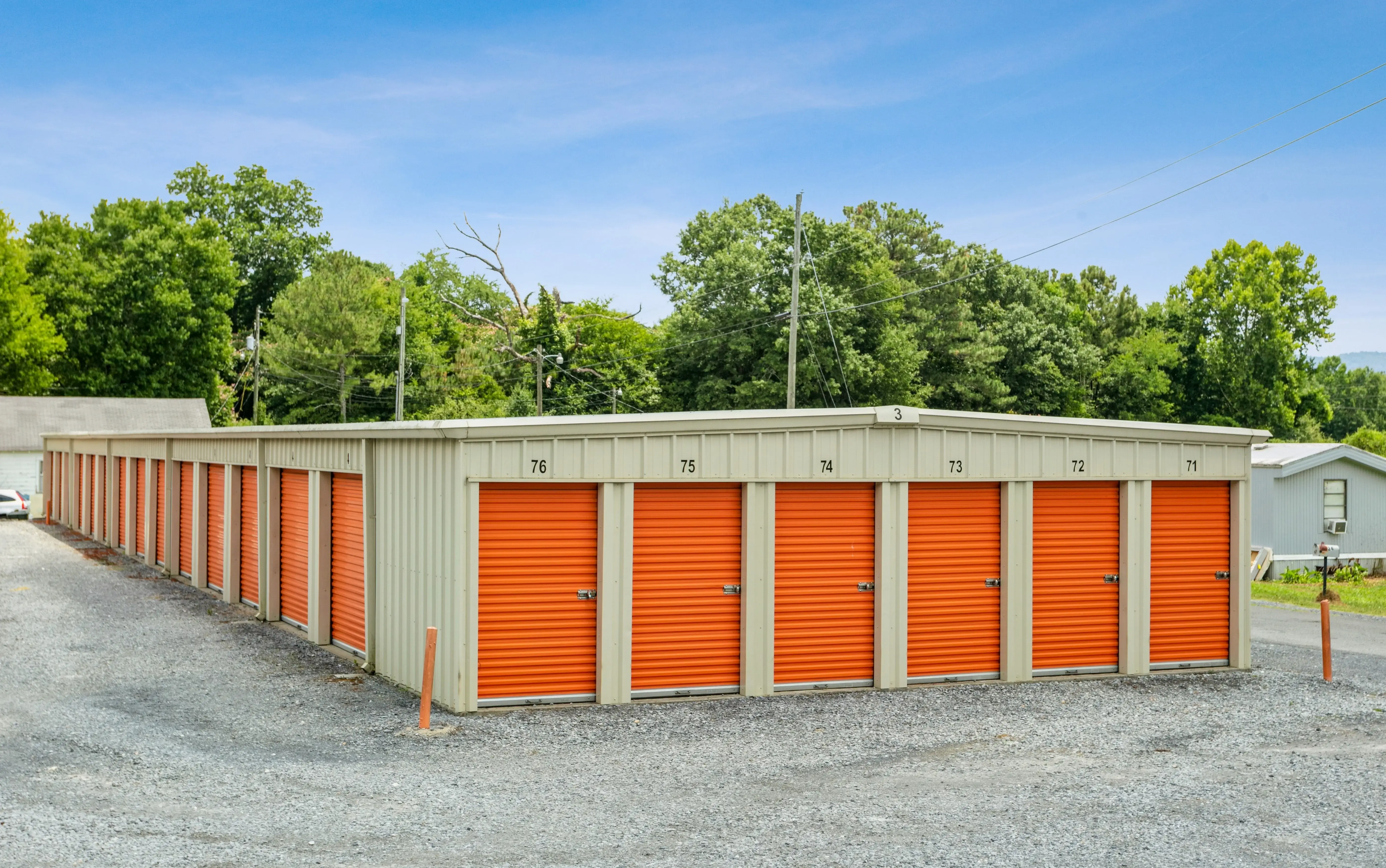 Exterior view of drive up storage units with orange roll up doors at our Summerville GA facility