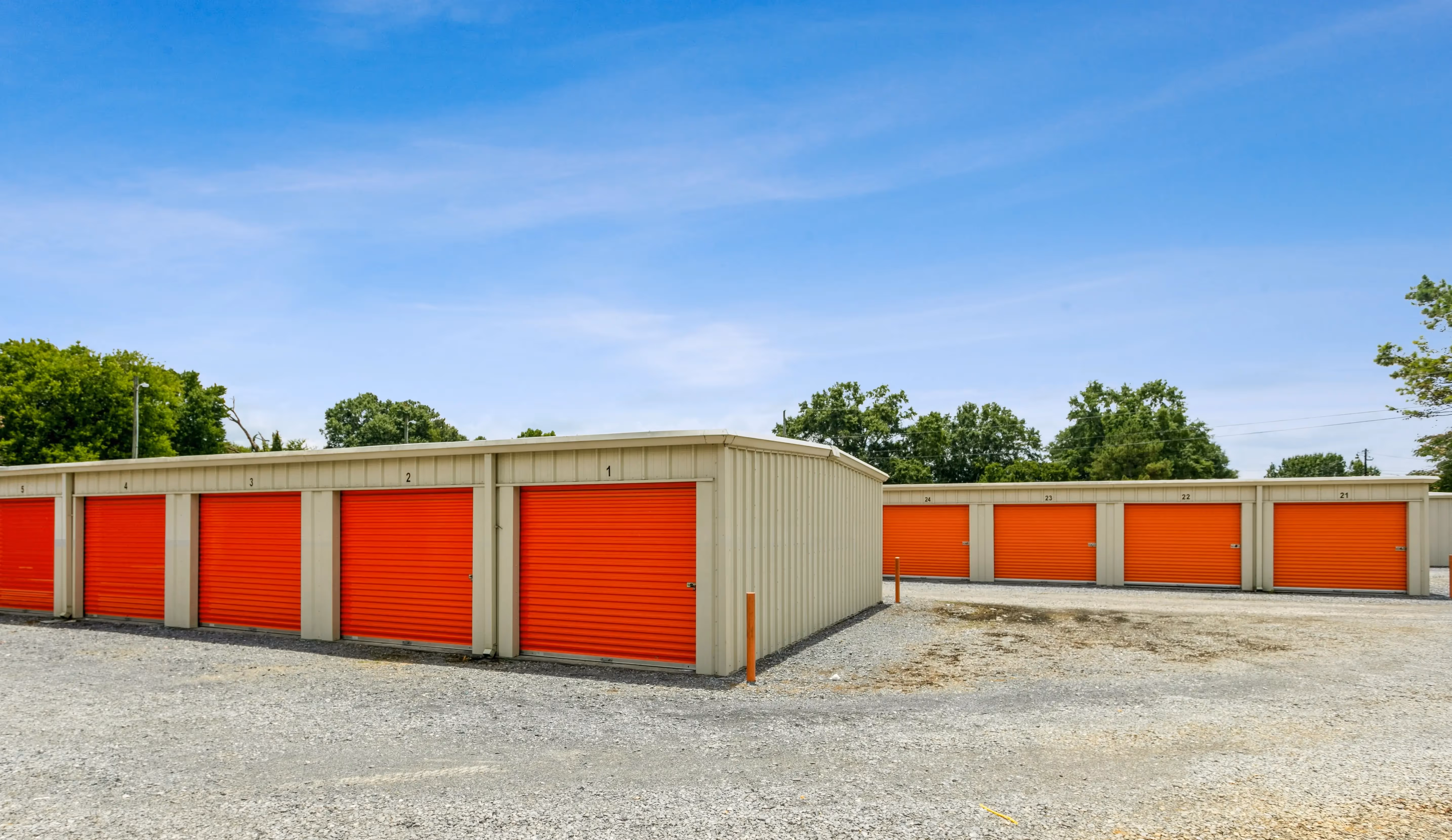 Drive up storage buildings with orange doors and gravel driveway at our Summerville GA location
