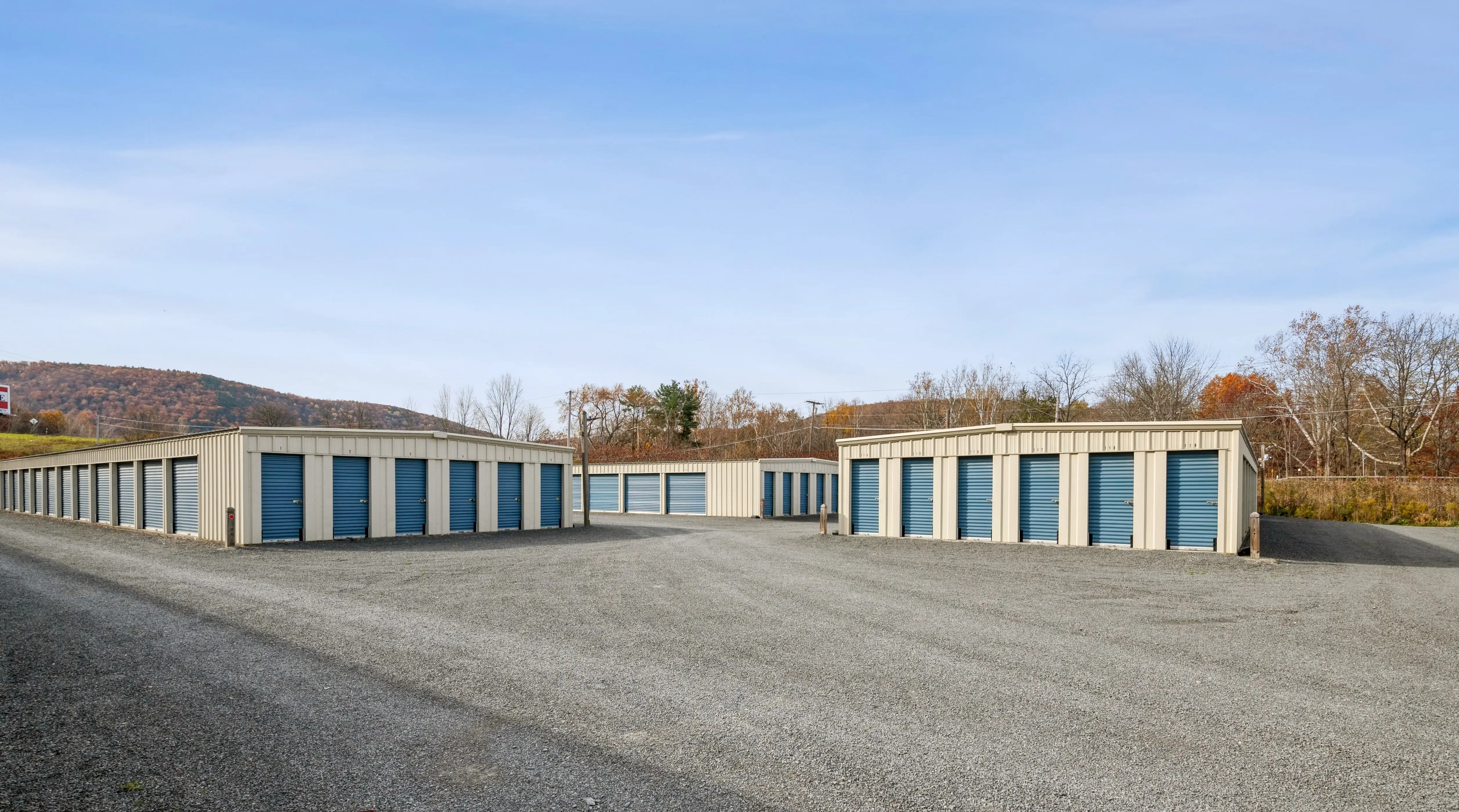 Exterior view of drive up storage units with blue roll up doors at our Elmira NY location