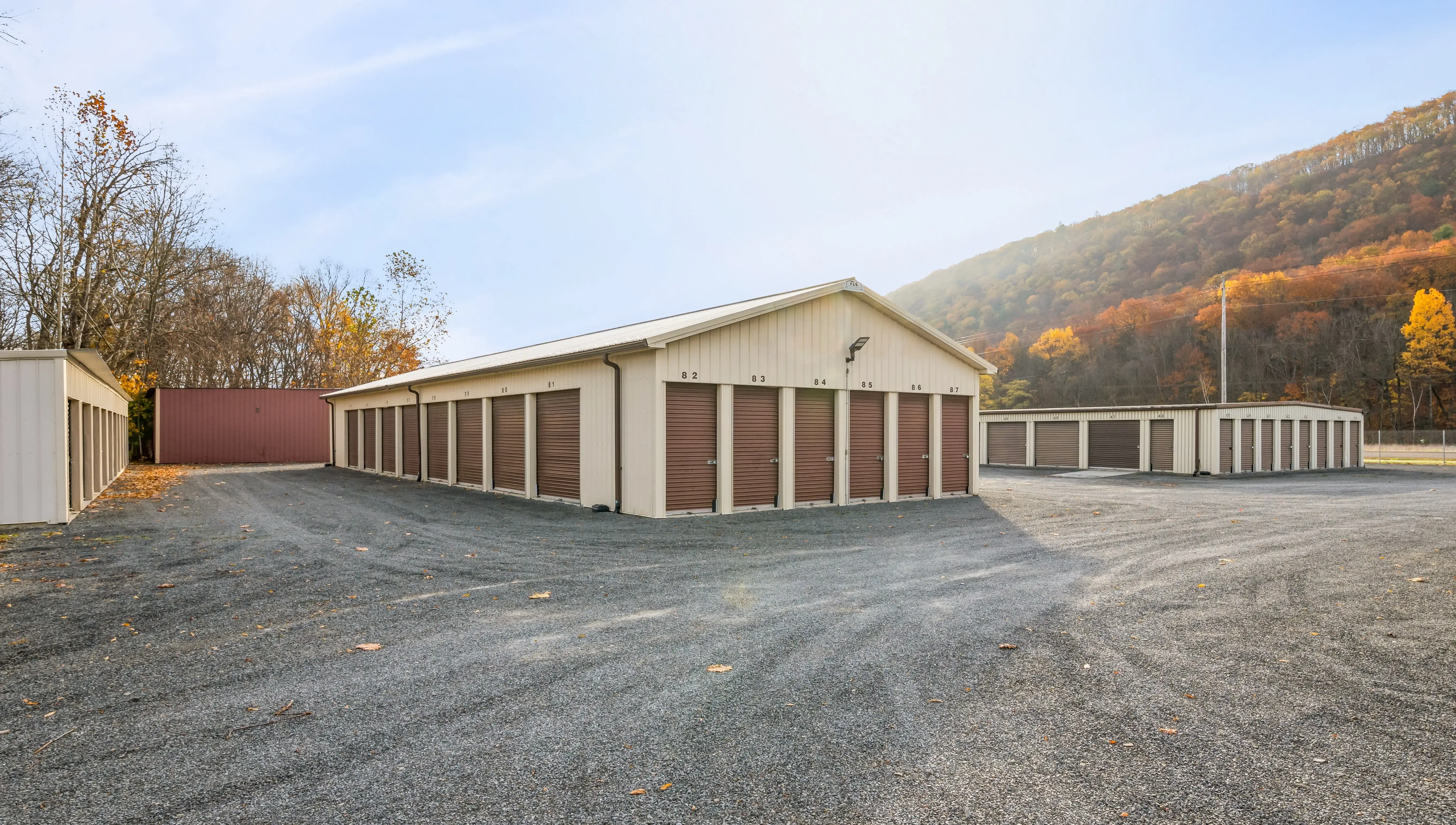 Exterior view of drive up storage buildings with tan doors at our Elmira NY location