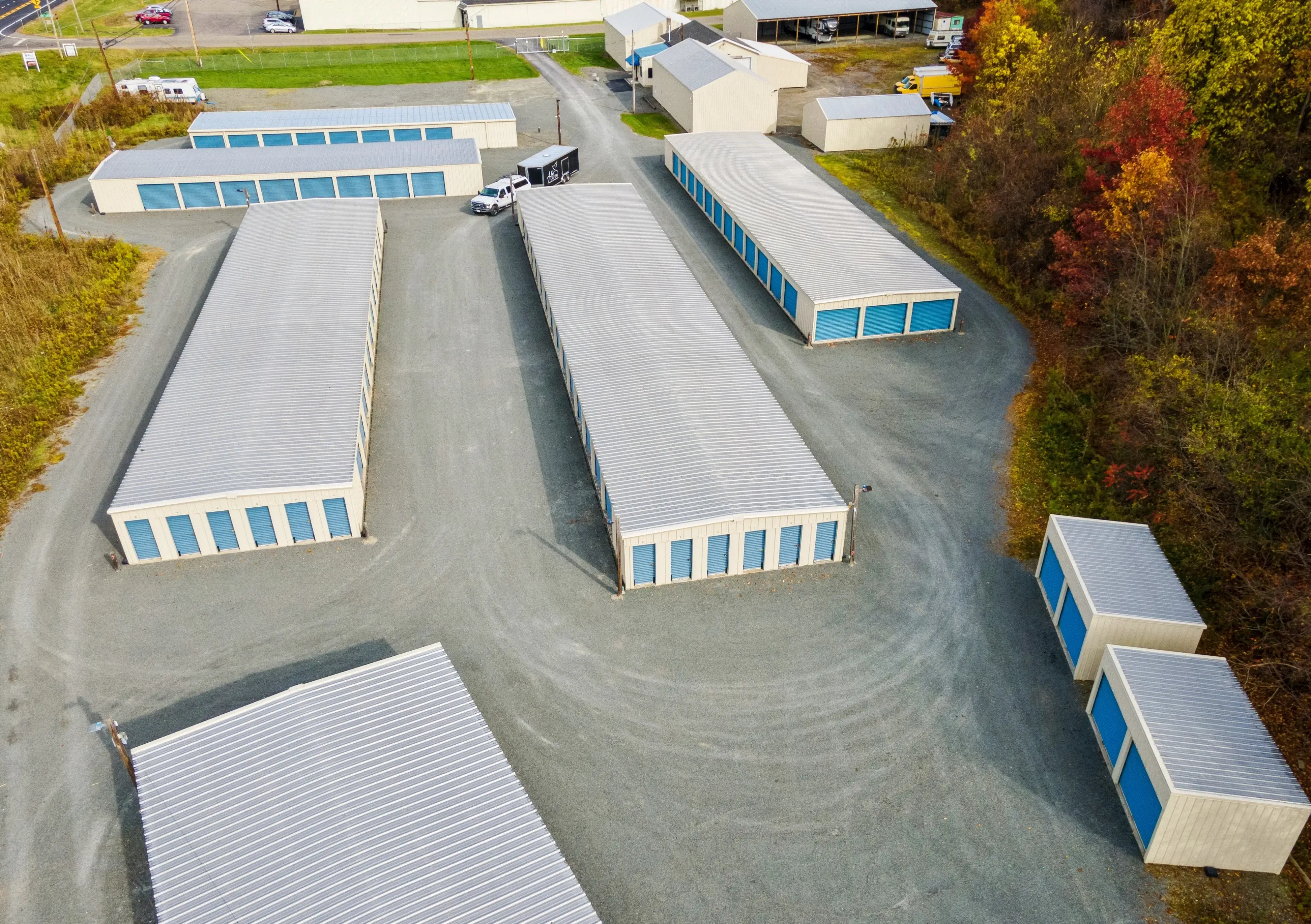 Aerial photo of storage buildings with blue doors and surrounding fall foliage in Elmira NY