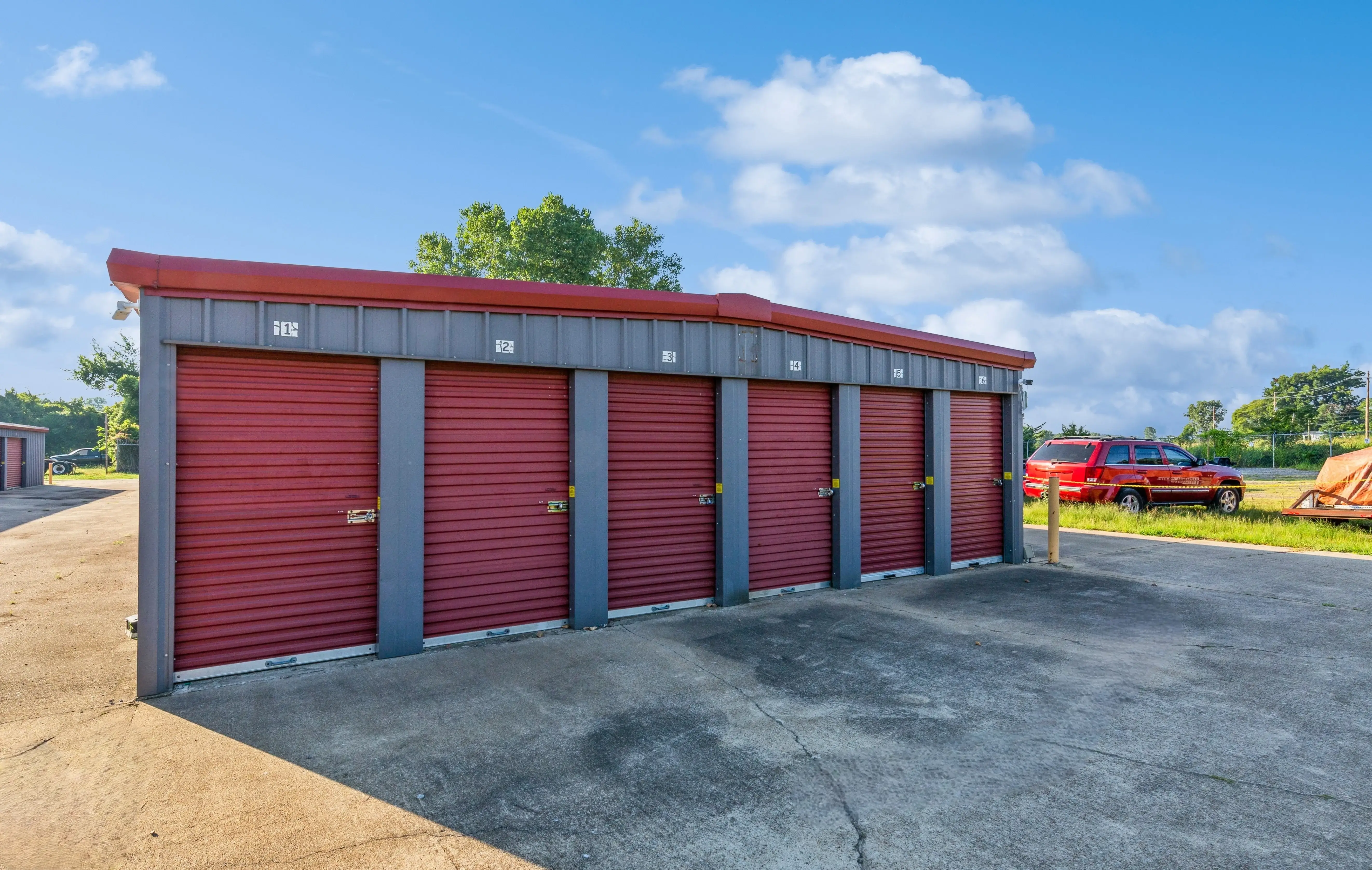 Front view of multiple red roll up storage units with open parking space in front at our Walls MS facility
