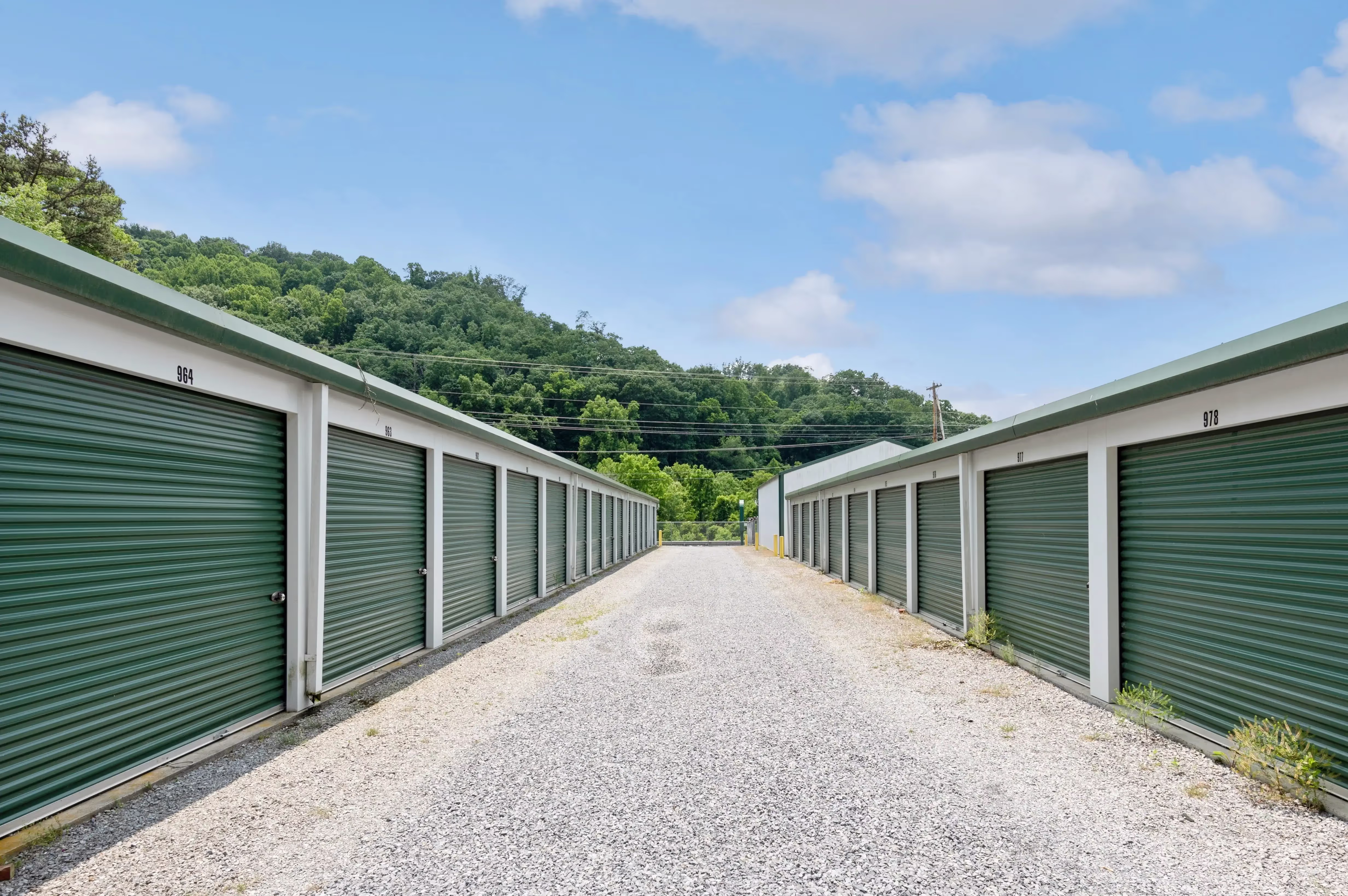Row of green door storage units along gravel driveway in Abingdon VA
