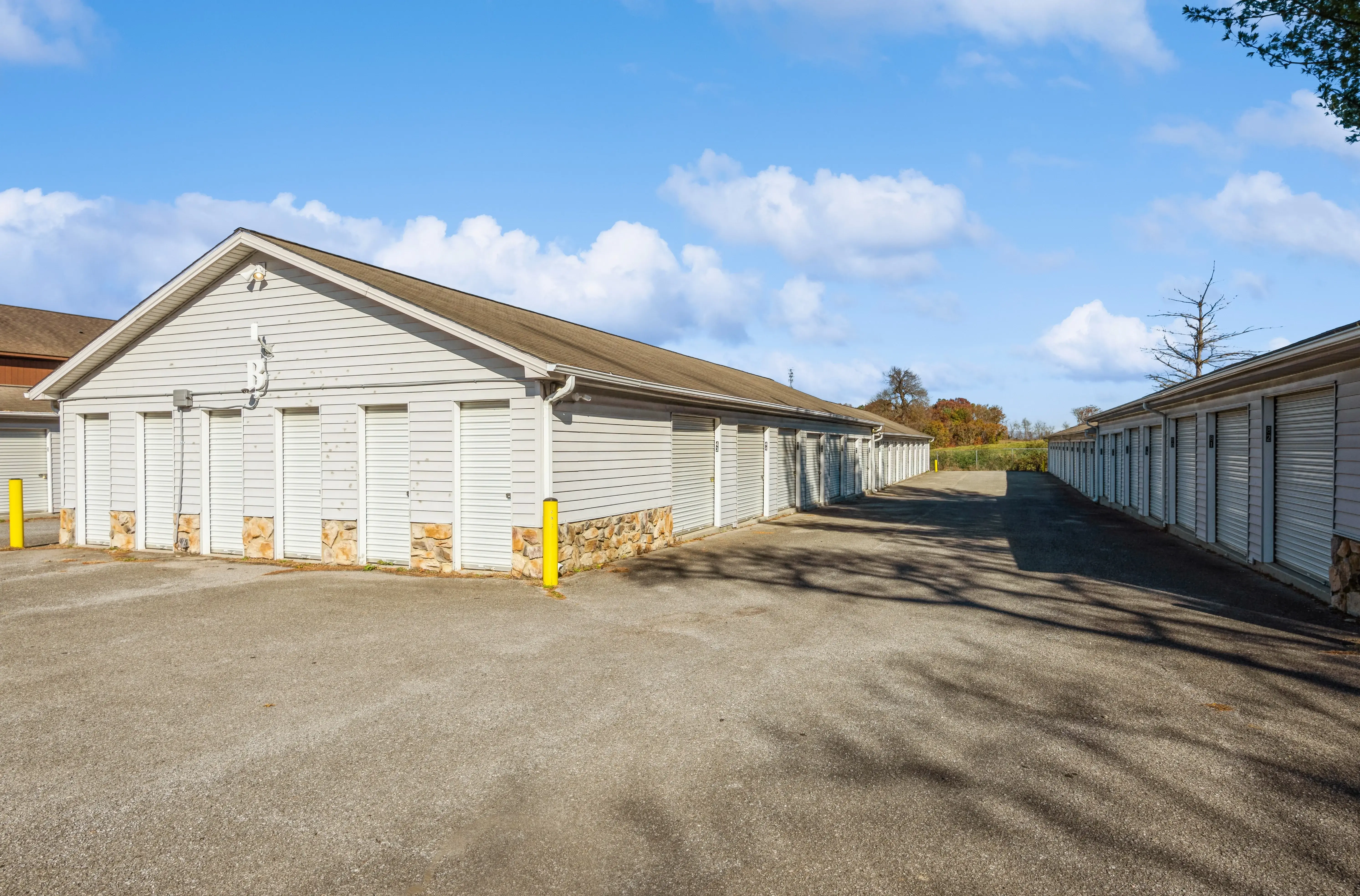 Exterior of drive up storage building with white doors and gravel driveway at our Christiansburg VA facility on Roanoke Street