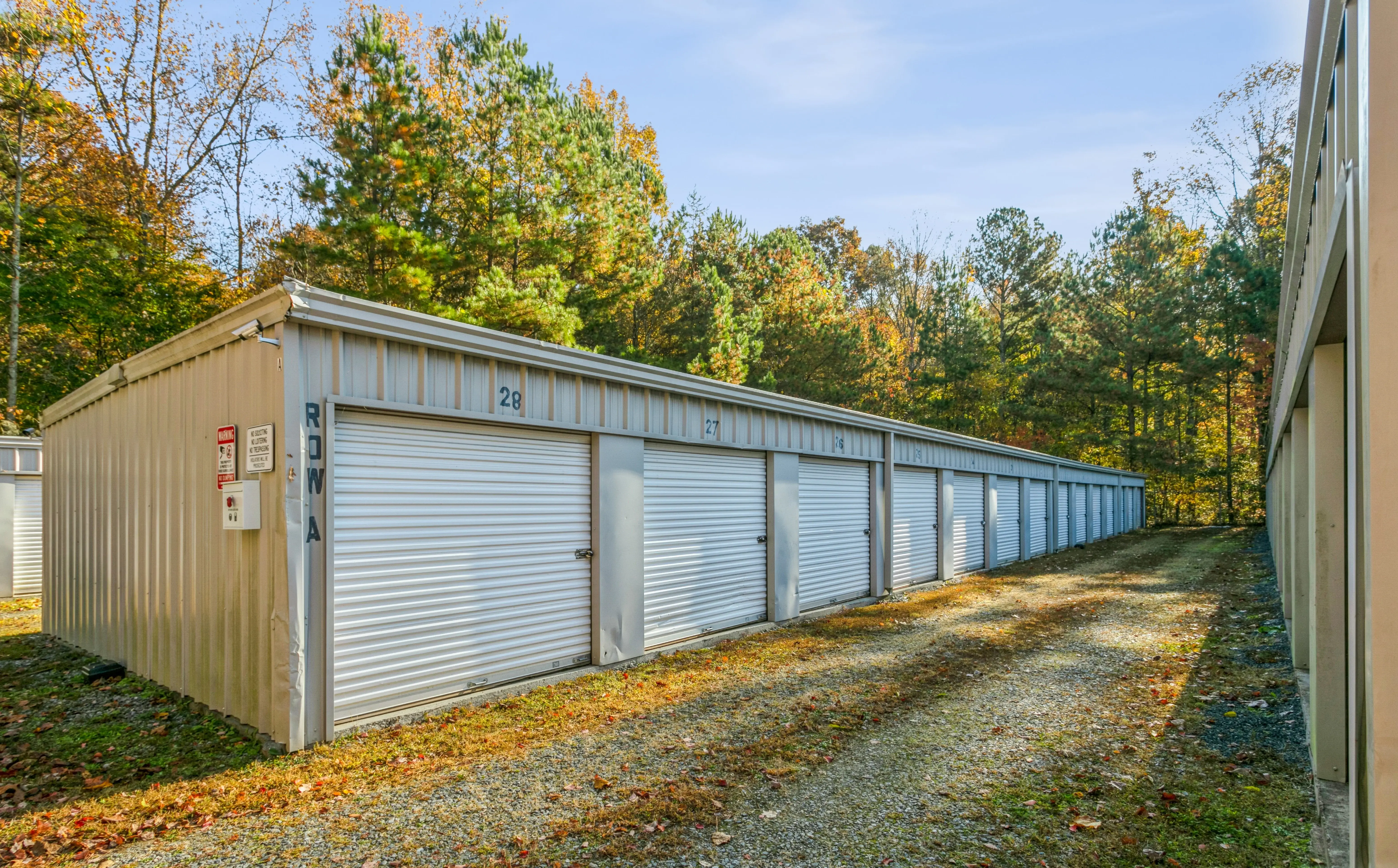 Drive up storage units with white roll up doors surrounded by trees at our Ellijay GA location