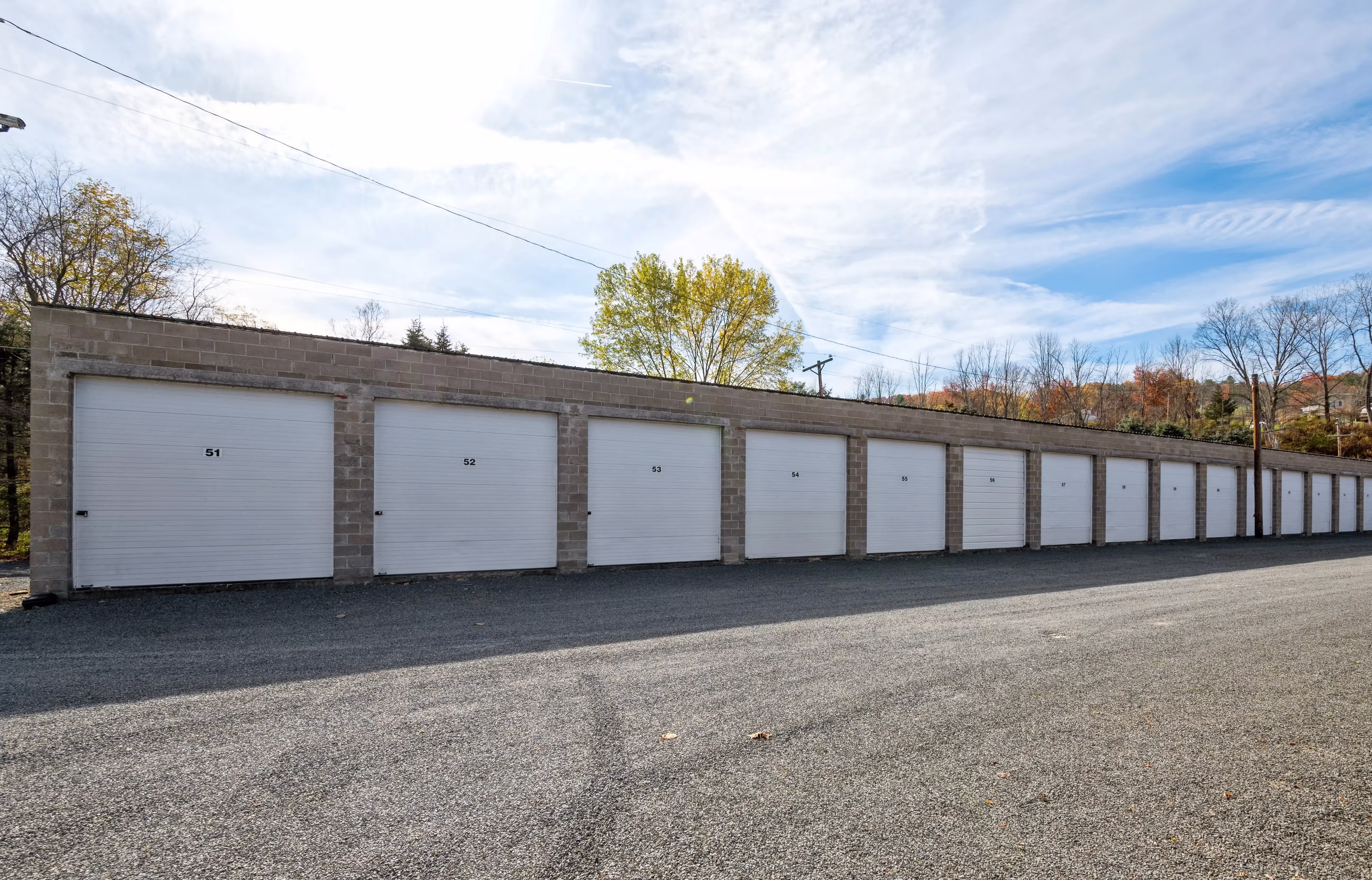 Row of drive up storage buildings with white doors in Gillett PA