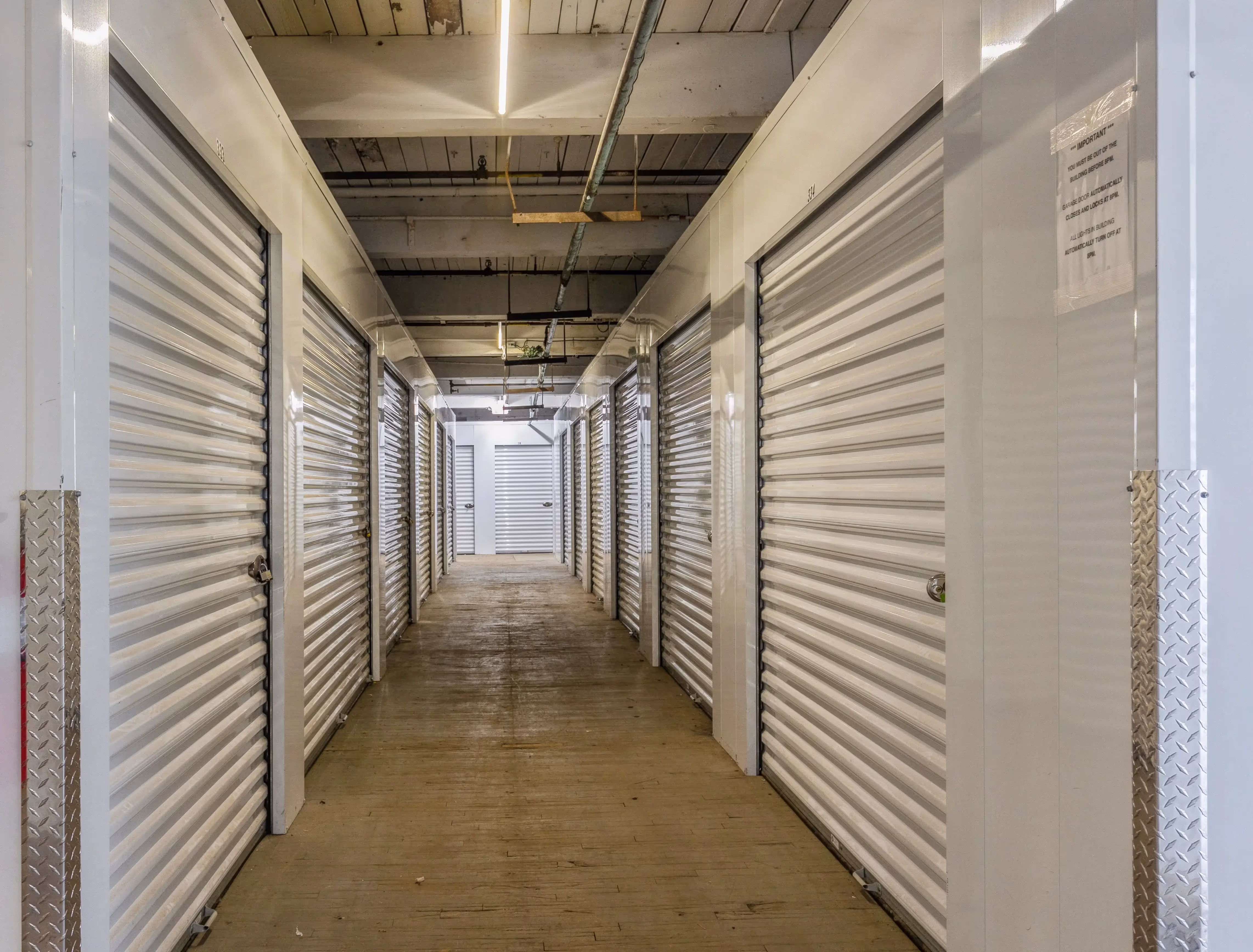 “Interior hallway of climate controlled storage units with white roll up doors in Gloversville NY
