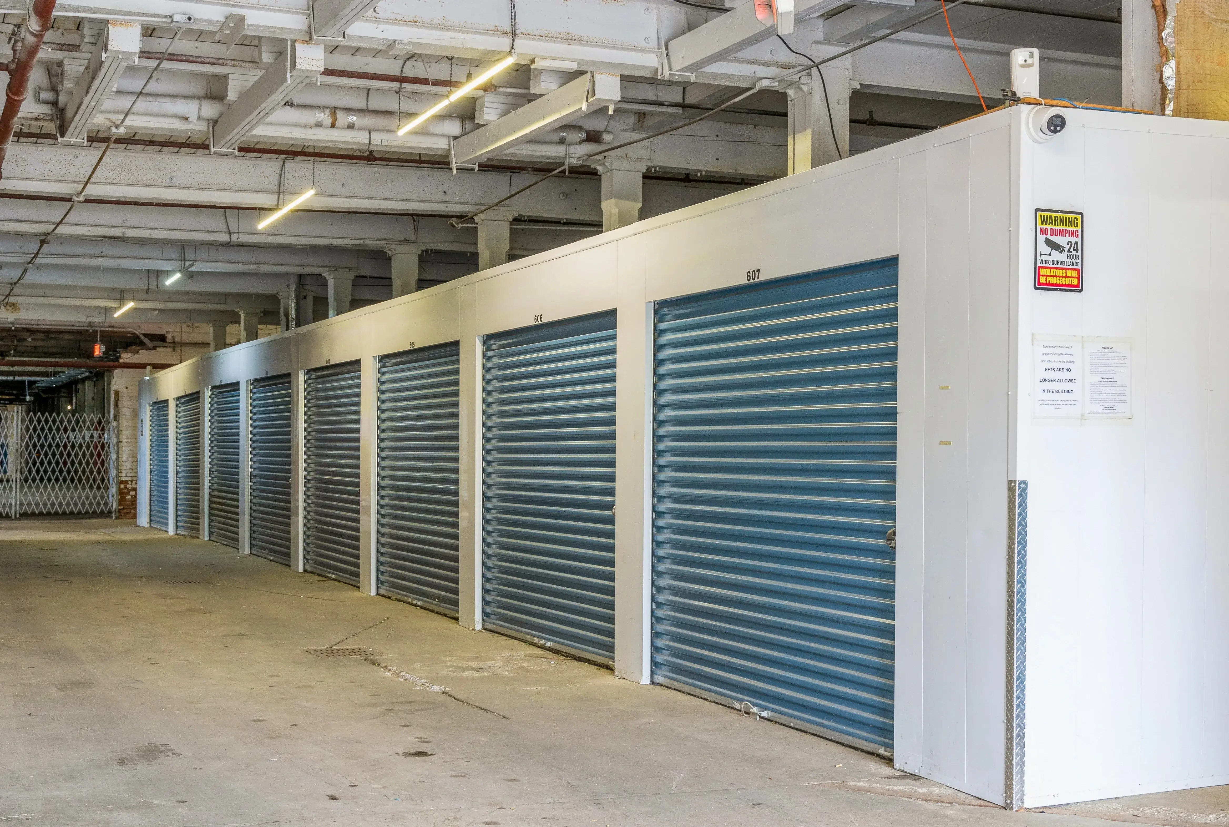 Row of indoor storage units with blue roll up doors at our Gloversville NY facility