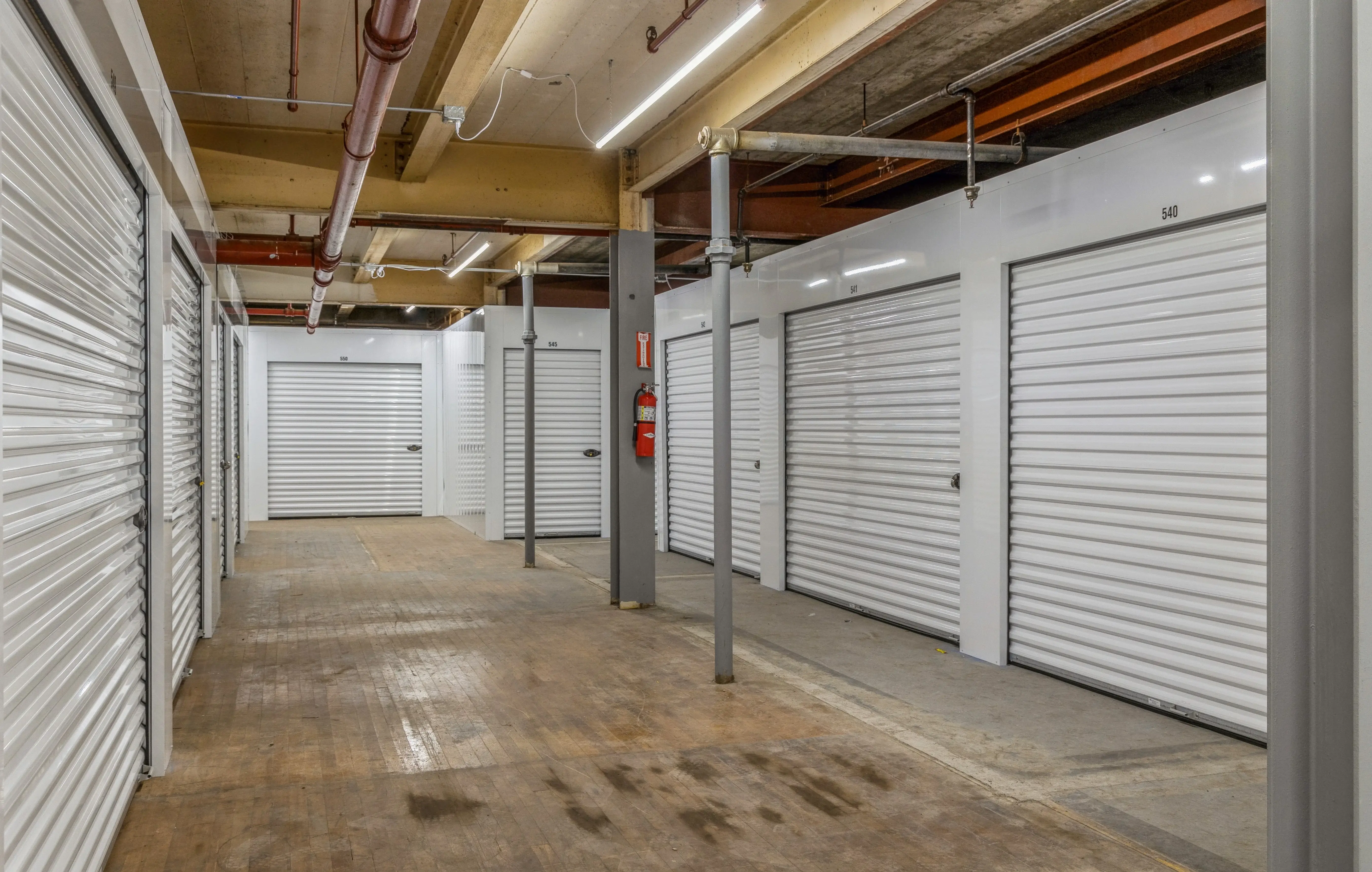 Interior hallway of climate controlled storage units with white roll up doors in Gloversville NY