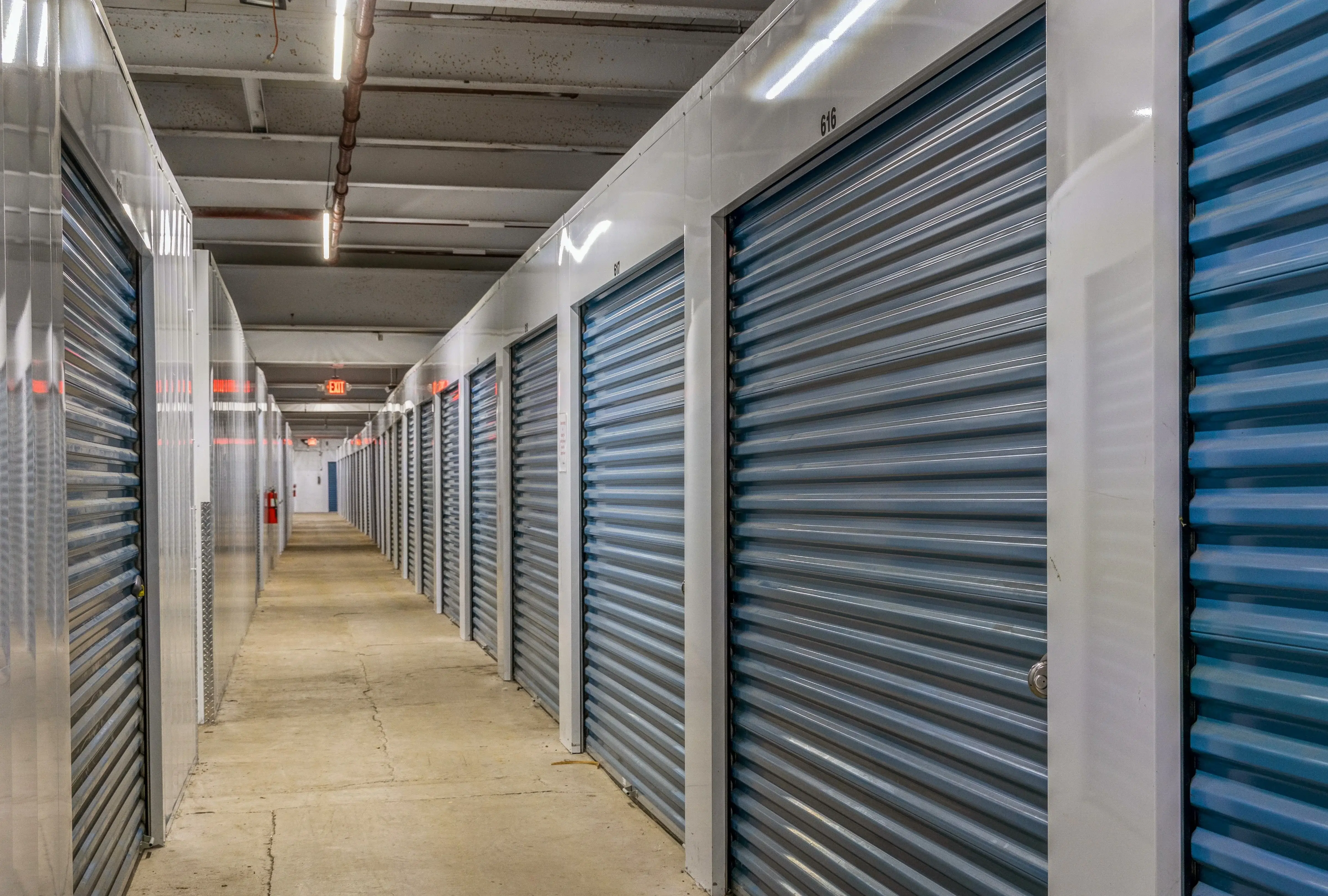 Row of indoor storage units with blue roll up doors at our Gloversville NY location