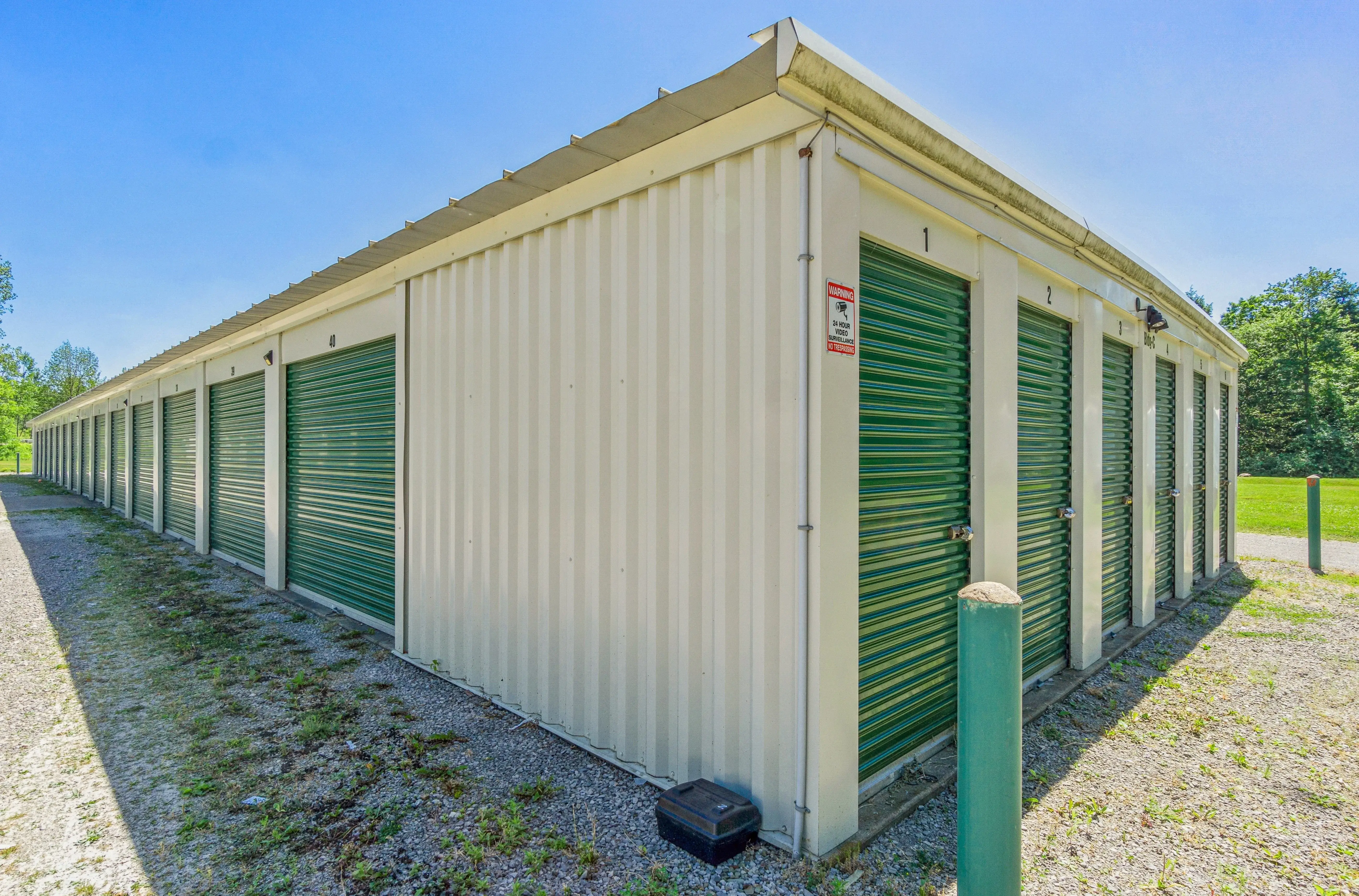 Angled exterior view of drive up storage buildings with green roll up doors at our McKean PA facility