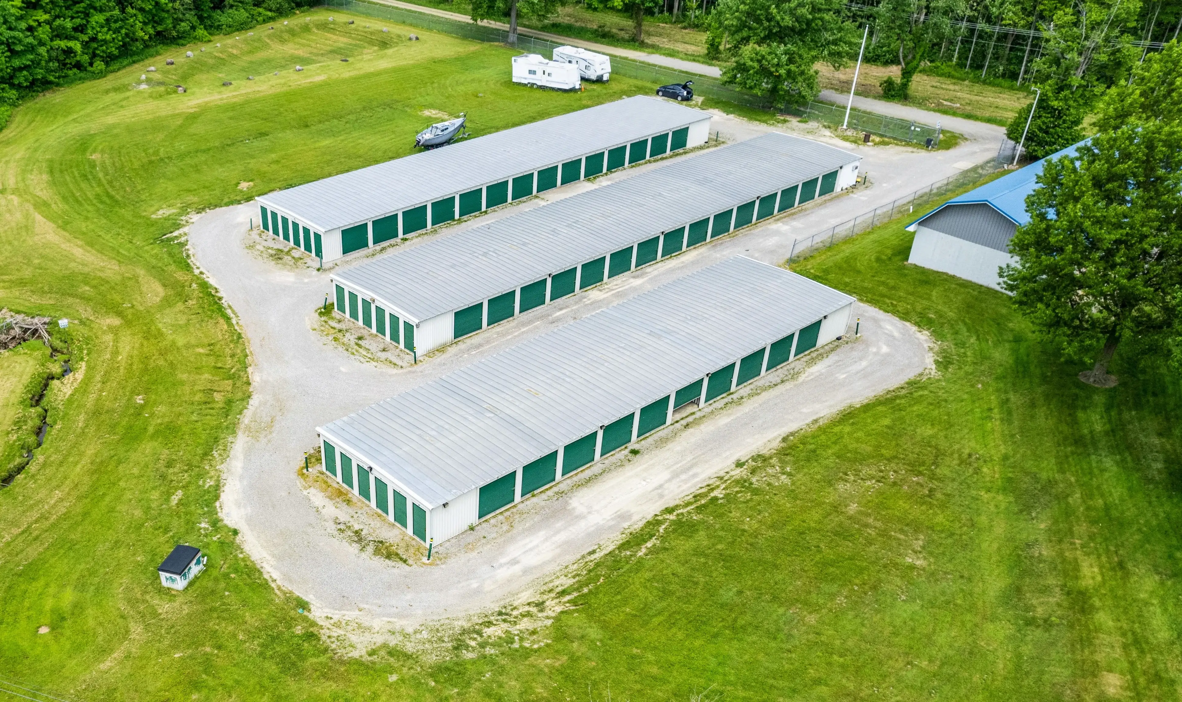 Aerial photo of drive up storage units with green doors and gravel access lanes in McKean PA