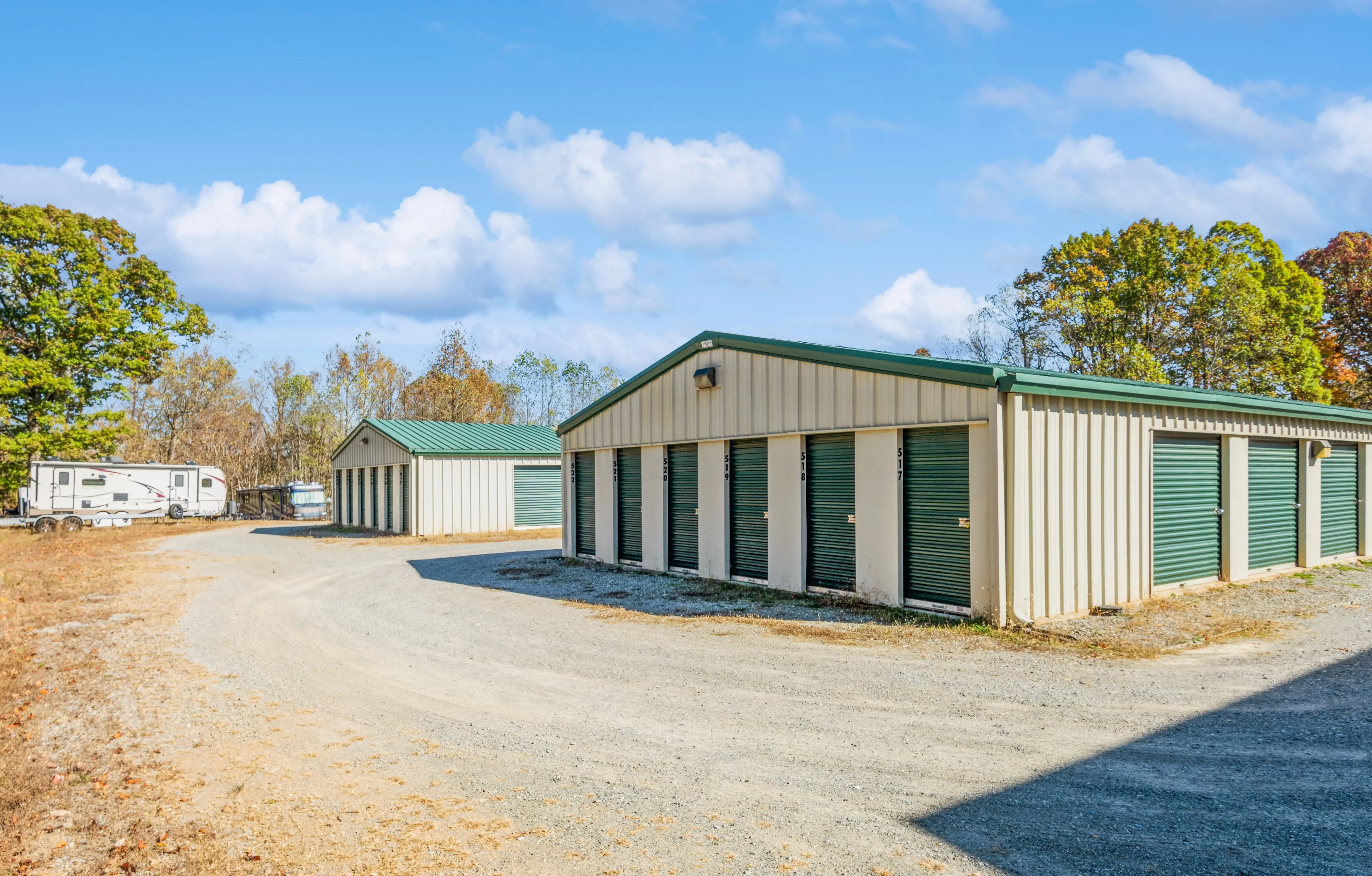 Drive up storage buildings with green doors and gravel driveway at our Moneta VA storage facility”