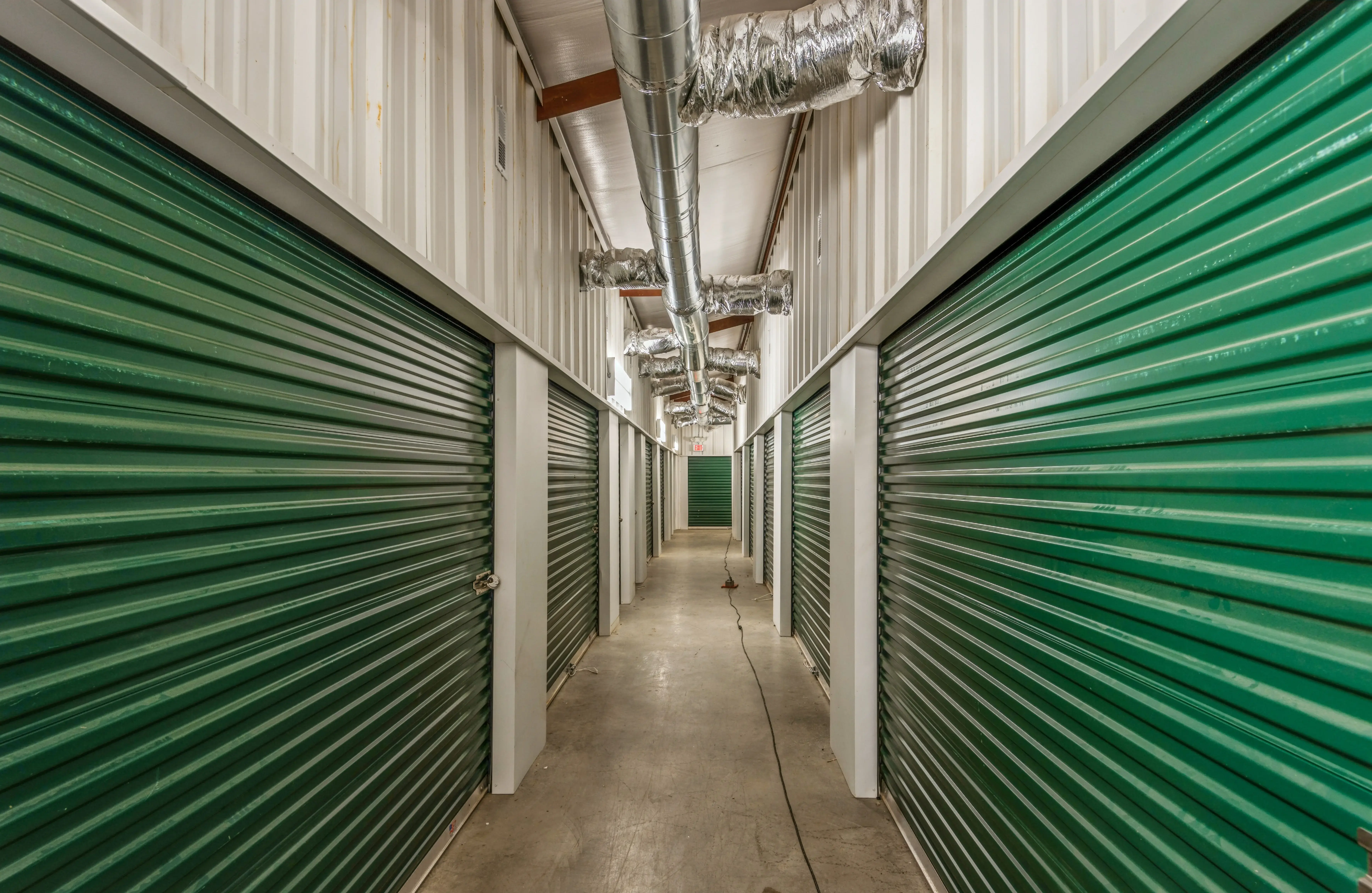 Interior hallway of climate controlled storage units with green roll up doors at our Moneta VA facility
