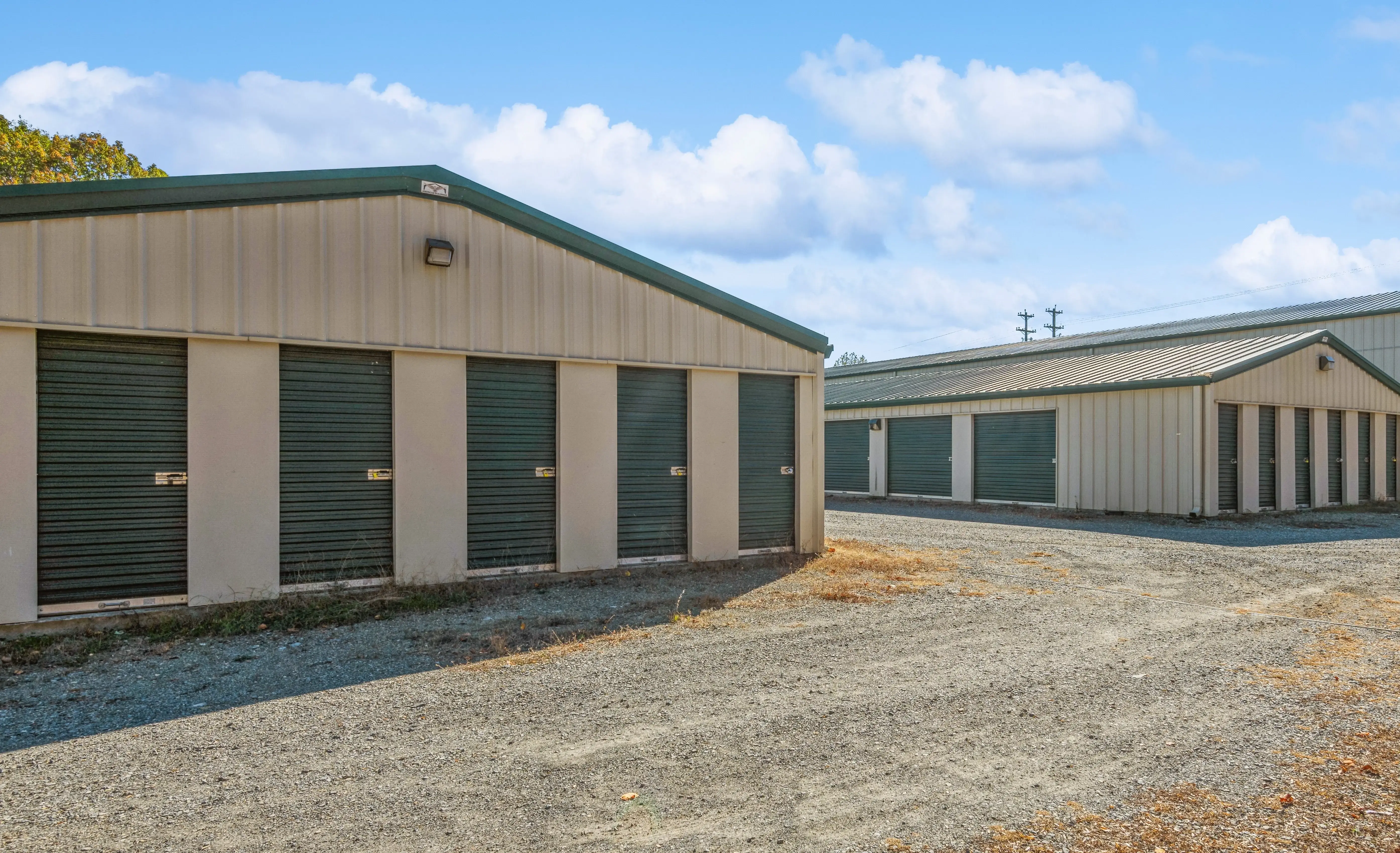 Row of drive up storage units with green roll up doors at our Moneta VA location