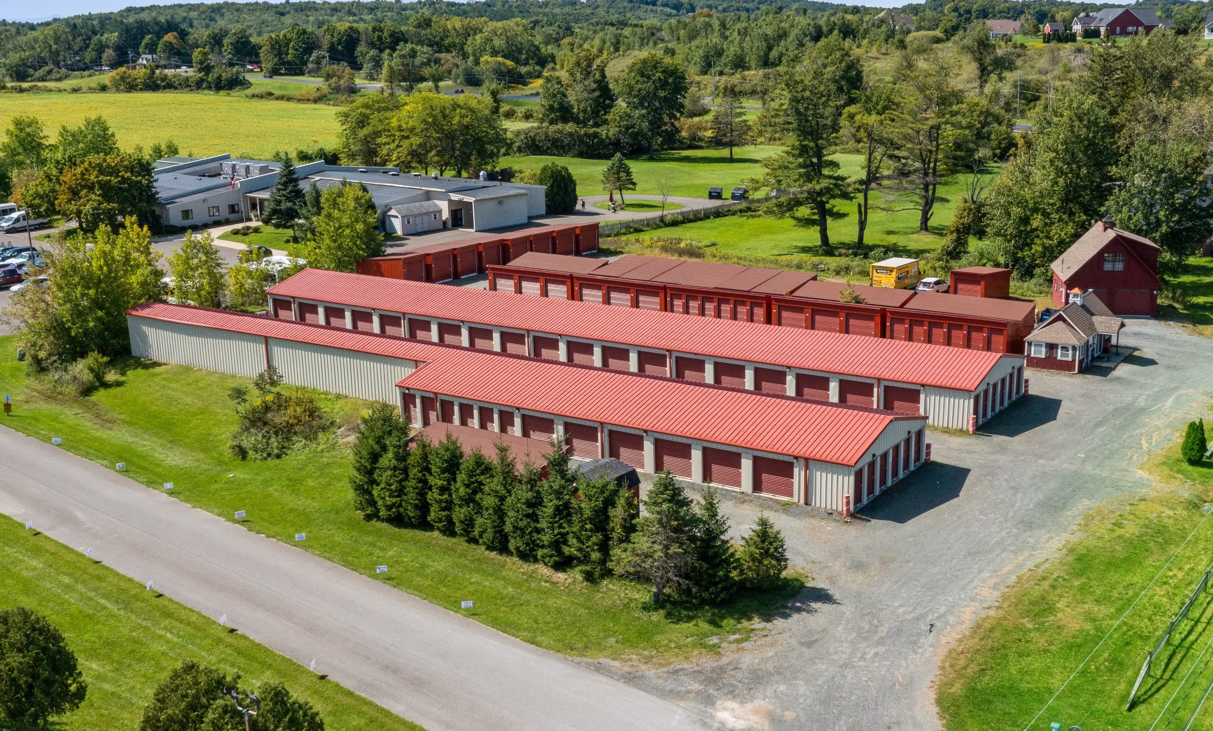 Aerial view of our Troy NY self storage facility with multiple rows of red door drive up units