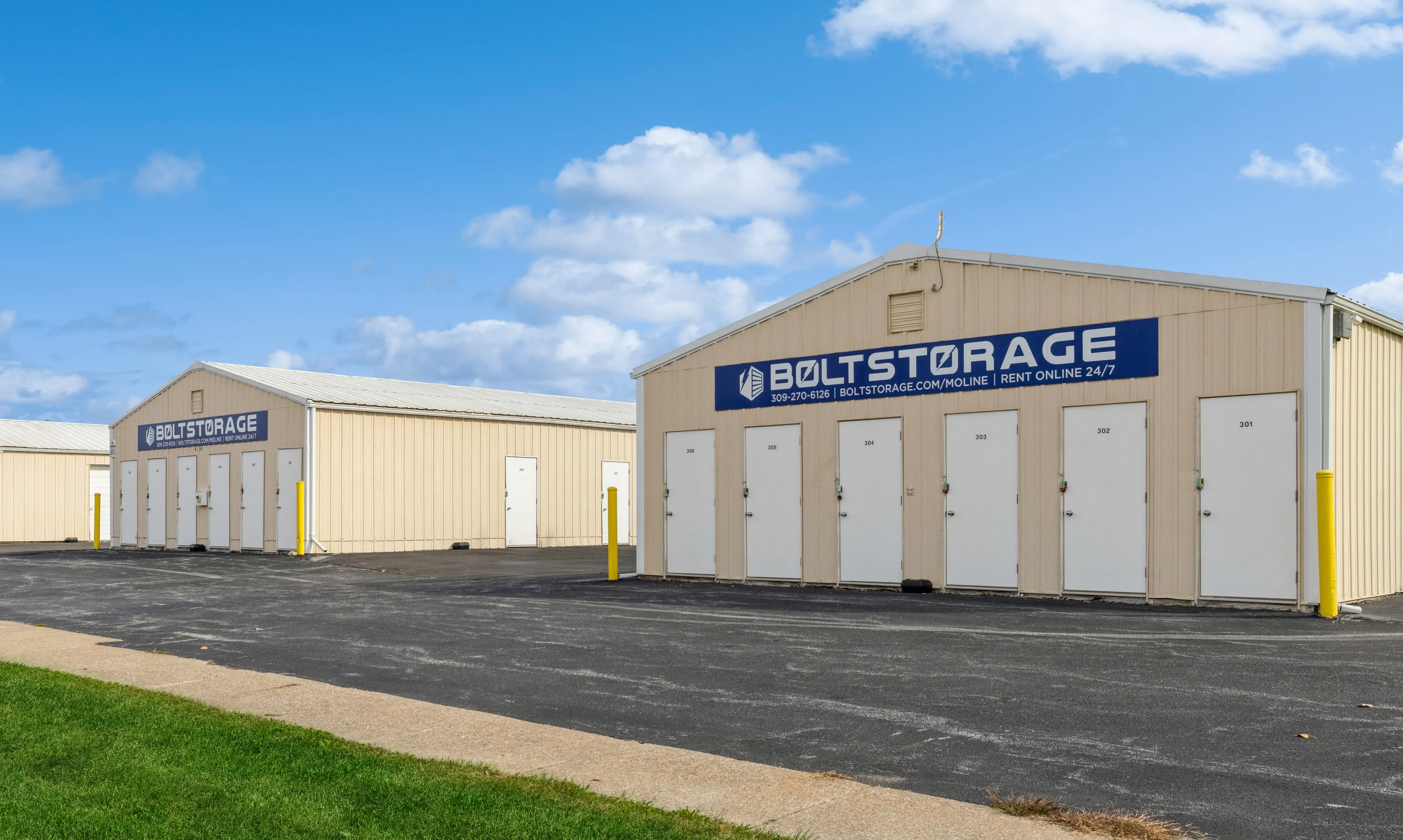 Drive up storage buildings with white roll up doors and paved access lanes in Moline IL