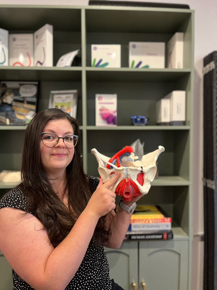 Restore Pelvic Health PT therapist holding a pelvic anatomy model in the clinic office