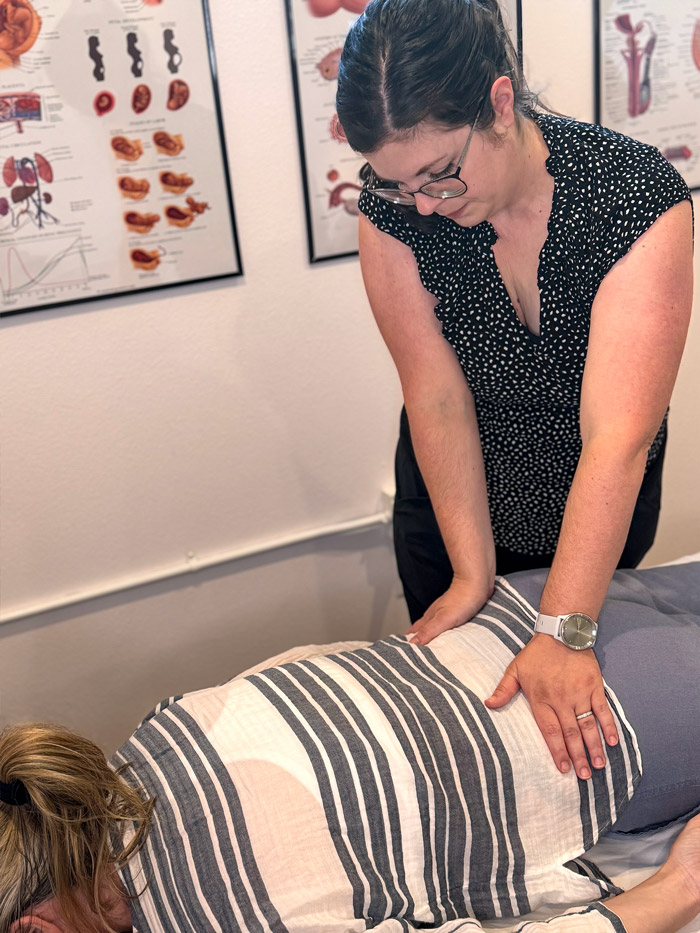 Pelvic floor physical therapist providing manual therapy to a patient in a side-lying position at Restore Pelvic Health PT