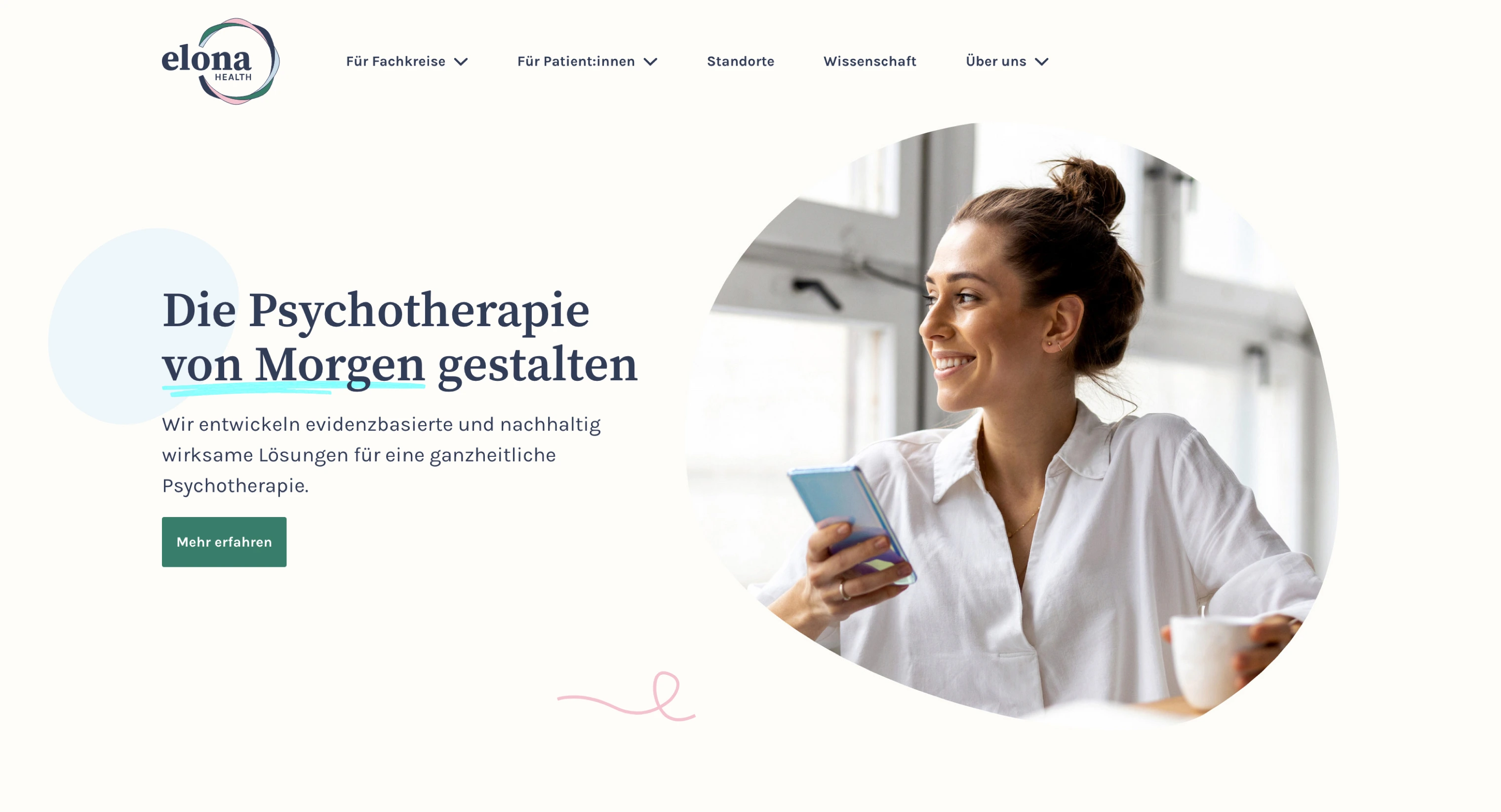 Smiling woman in white shirt holding a smartphone and a cup, looking out of a window.