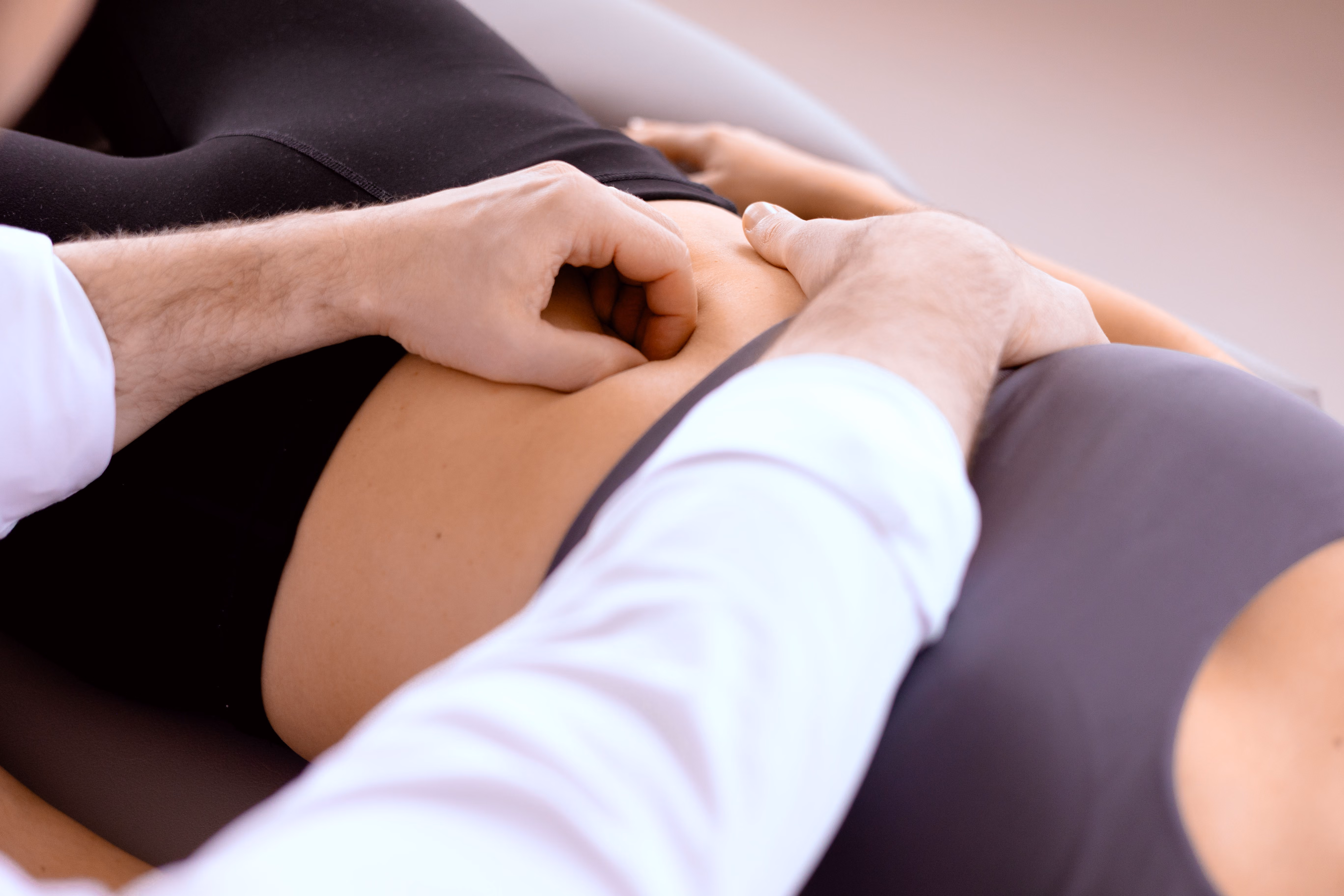 Viszerale Osteopathie: Behandlung am Bauch einer Patientin