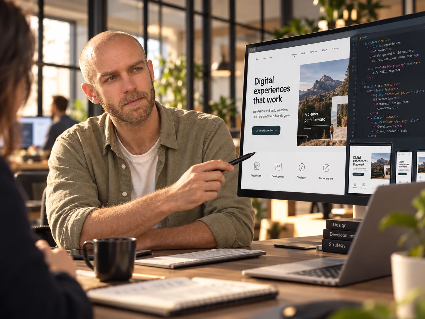 Een ontwerper bespreekt het ontwerp van een website op een groot scherm.