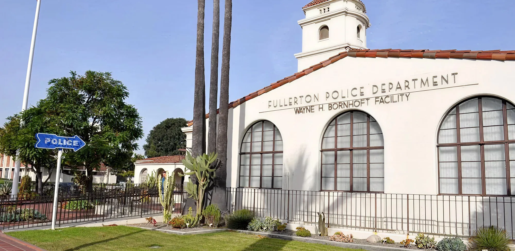 Exterior of the Fullerton Police Department Wayne H. Bornhoft Facility building with large arched windows and palm trees nearby.