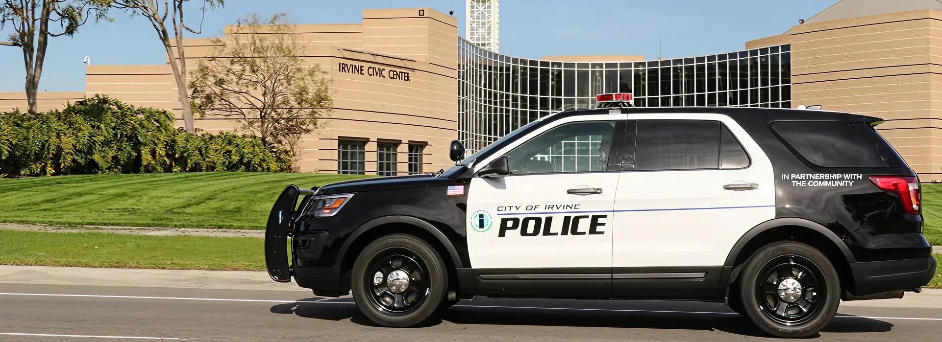 City of Irvine police SUV parked in front of the Irvine Civic Center building on a sunny day.