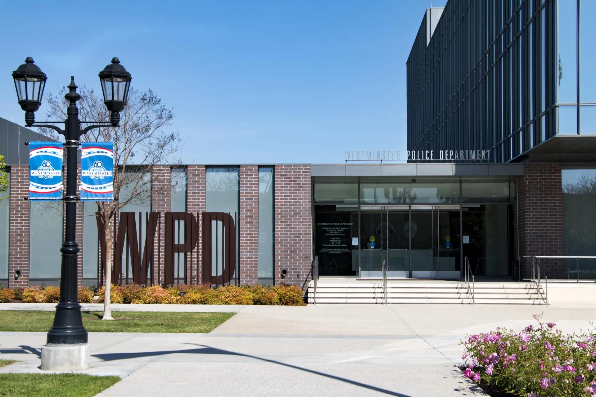 Exterior of the Westminster Police Department building with large metal WPD letters and clear blue sky.