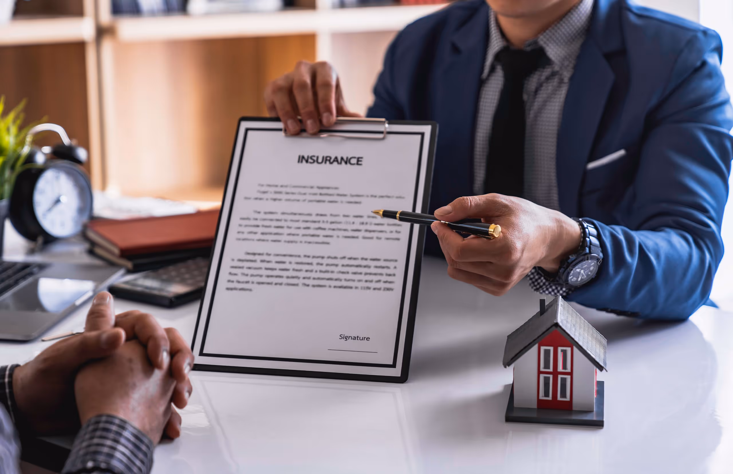 A roofing salesman pointing out an insurance claim document while helping an Oklahoma home owner understand their policy for storm damage restoration.