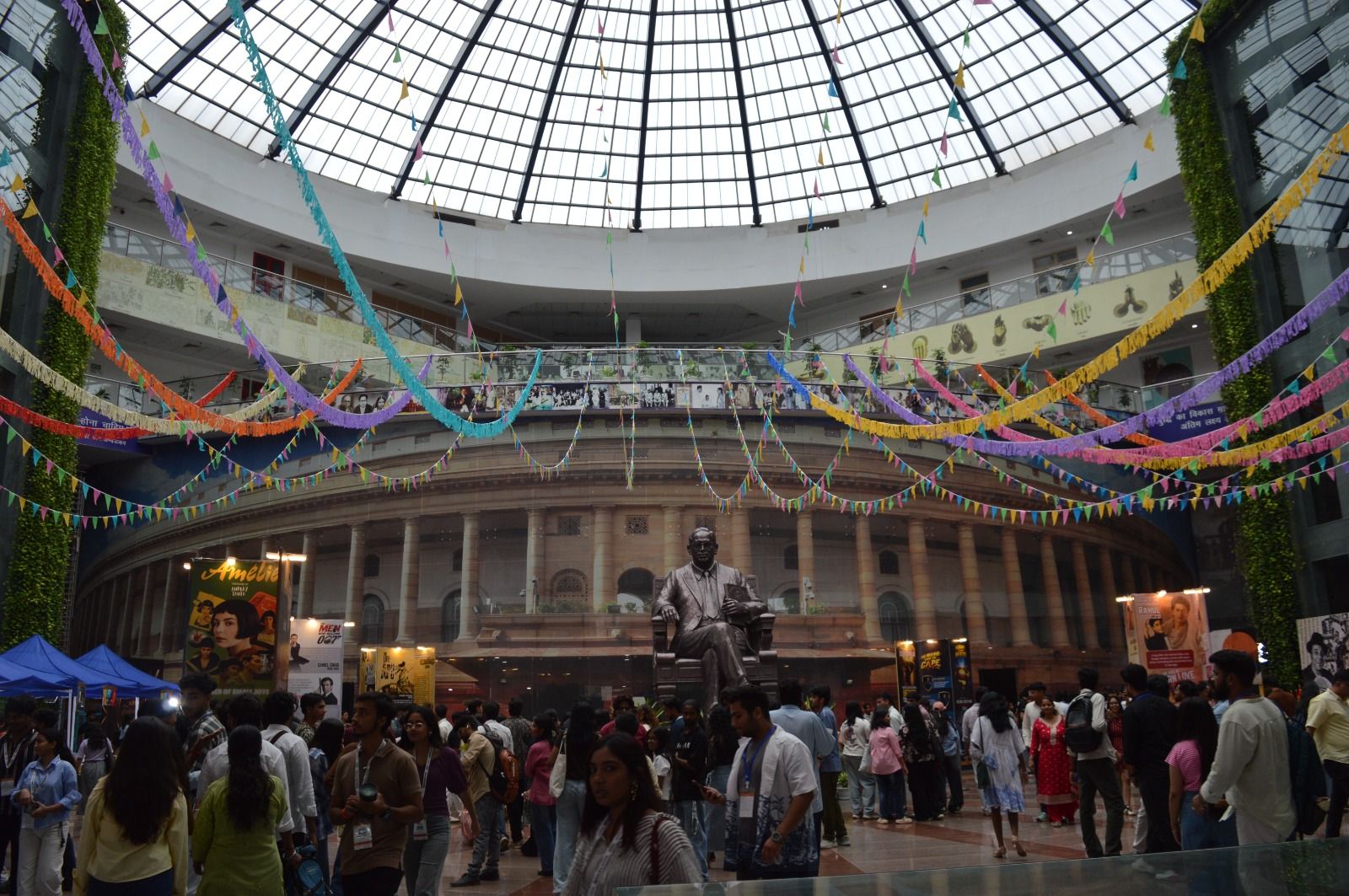 Festival visitors beneath colourful bunting in the venue atrium